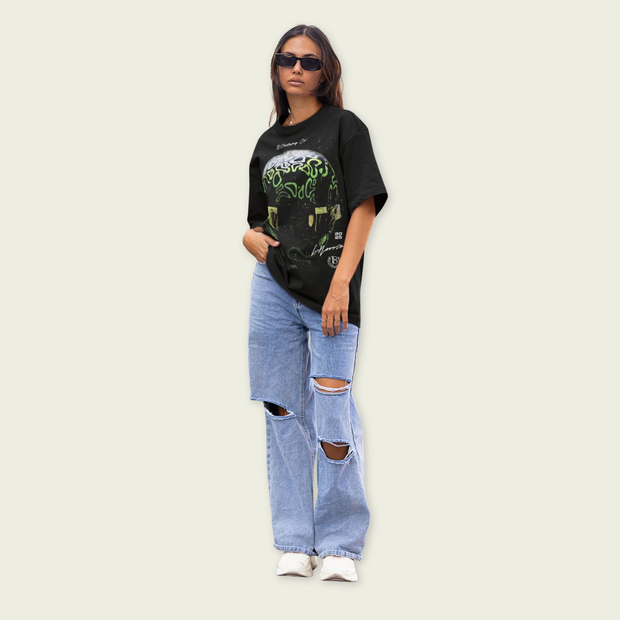 Person wearing a black graphic t-shirt and ripped jeans on a light background