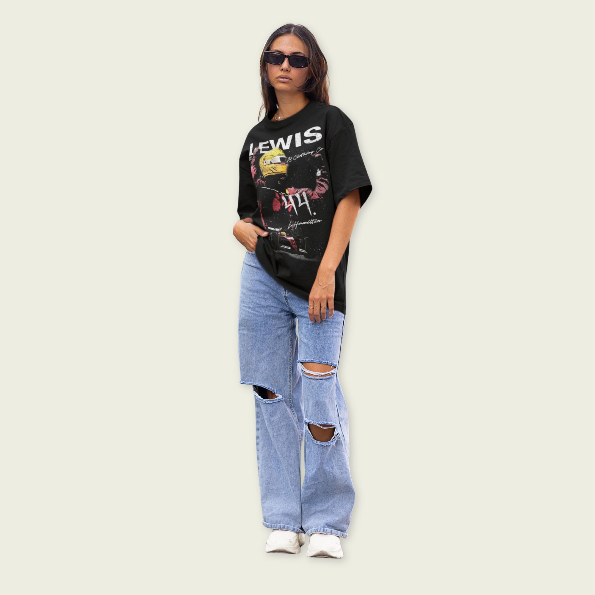 Person wearing a black graphic t-shirt and ripped jeans on a light background