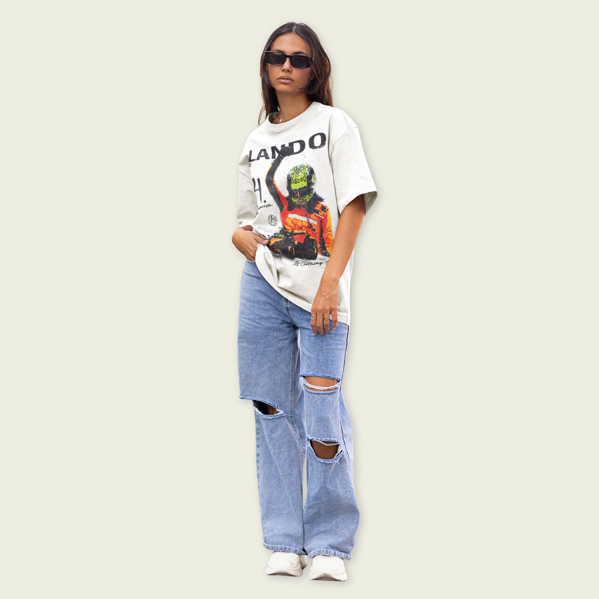 Person wearing a graphic t-shirt and ripped jeans on a plain background