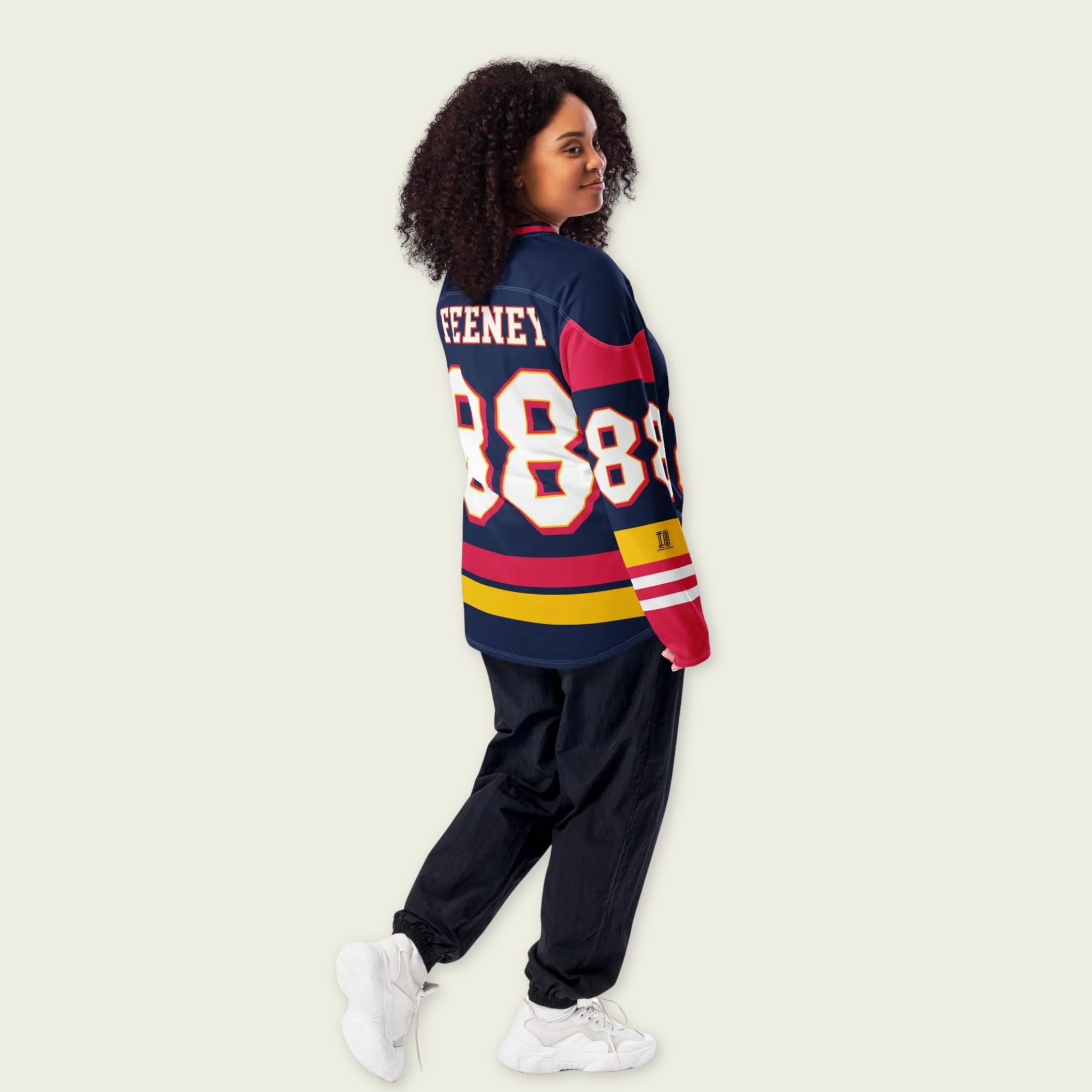 Person wearing a colorful sports jersey with numbers on a plain background