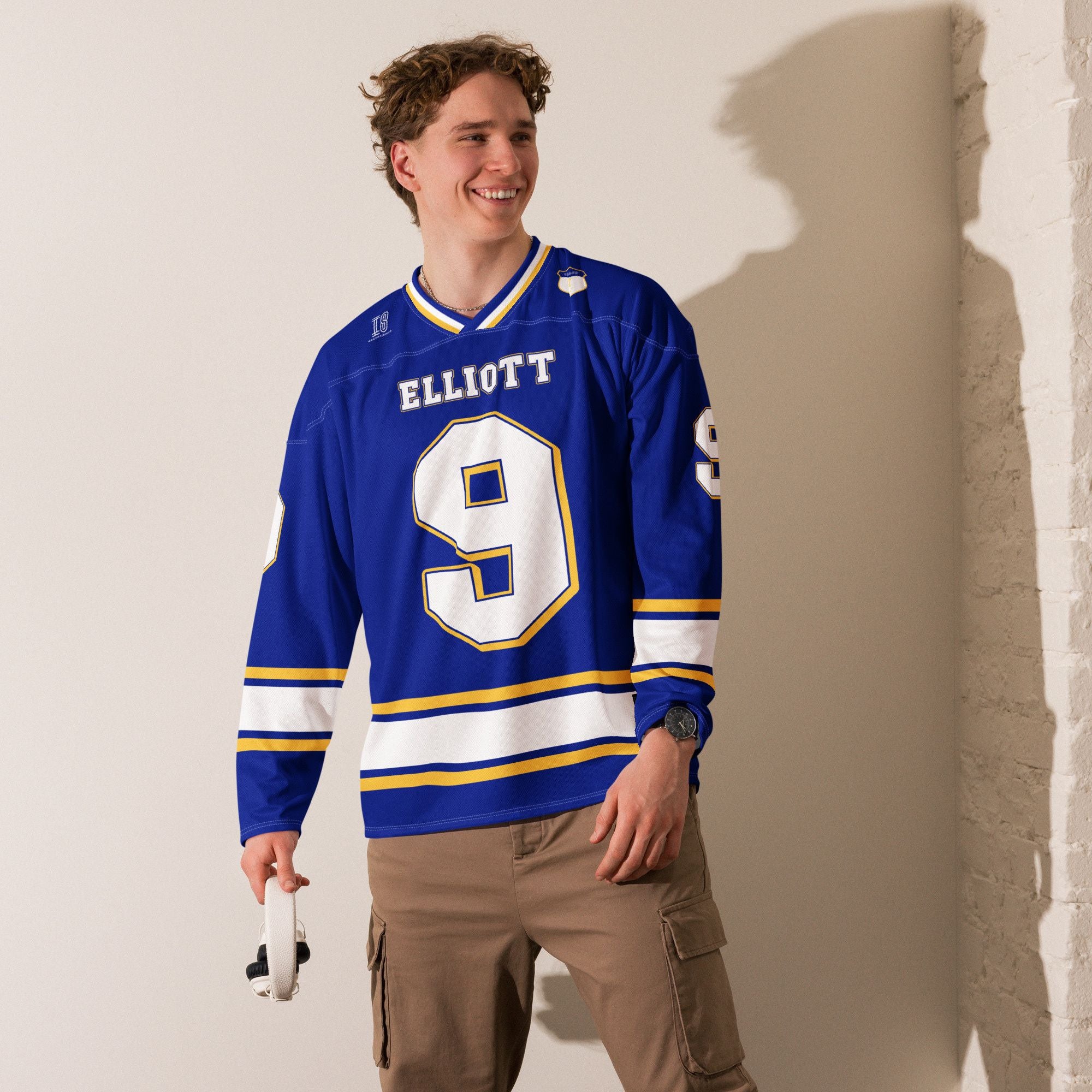 A Navy blue, white, and gold hockey jersey showing Chase Elliot's Nascar racing number 9 on the front and back with his name as well.
