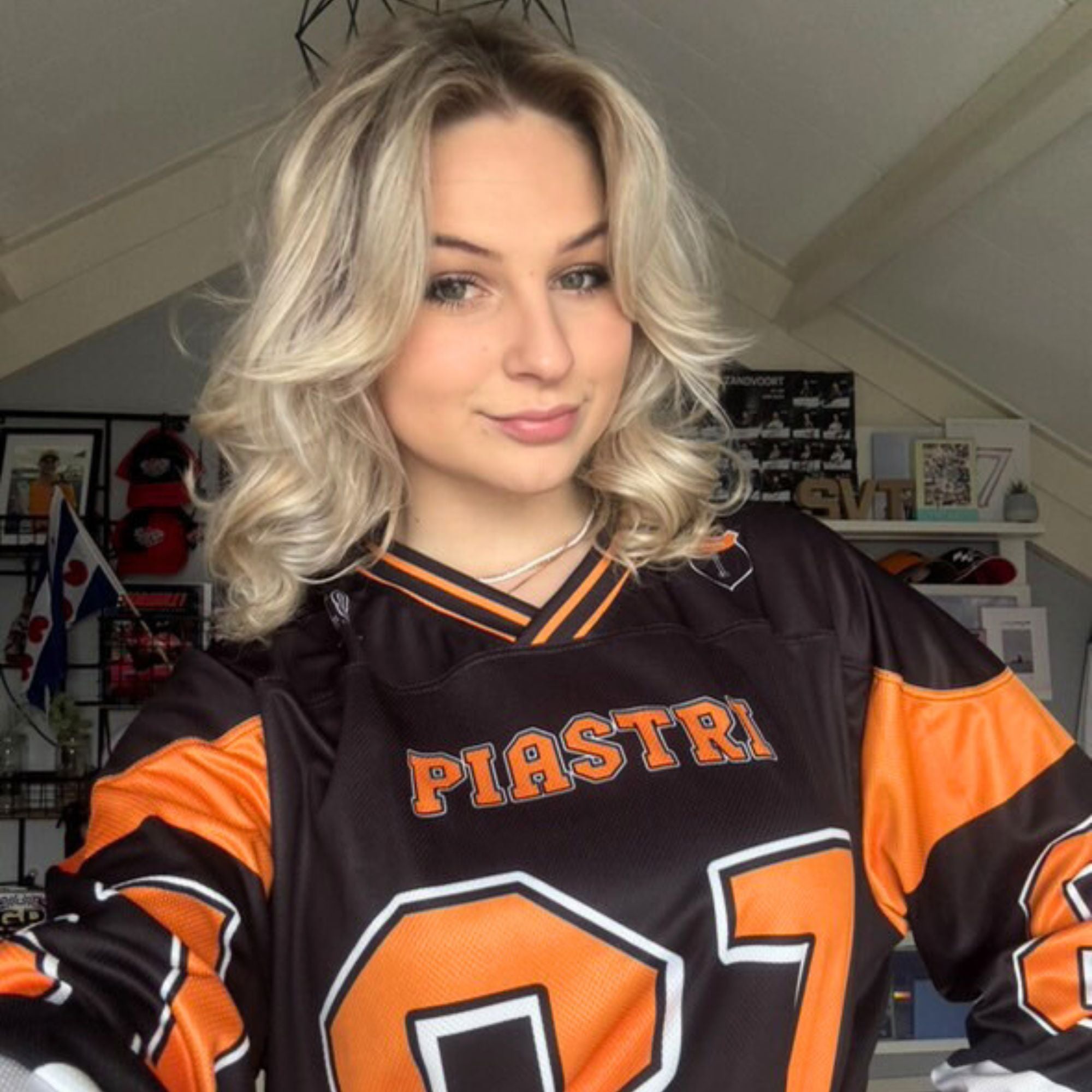 A black hockey jersey with Osacr Piastri's mclaren F1 racing number 81 on the front and back in papaya orange, also the name norris is on the back and front in orange