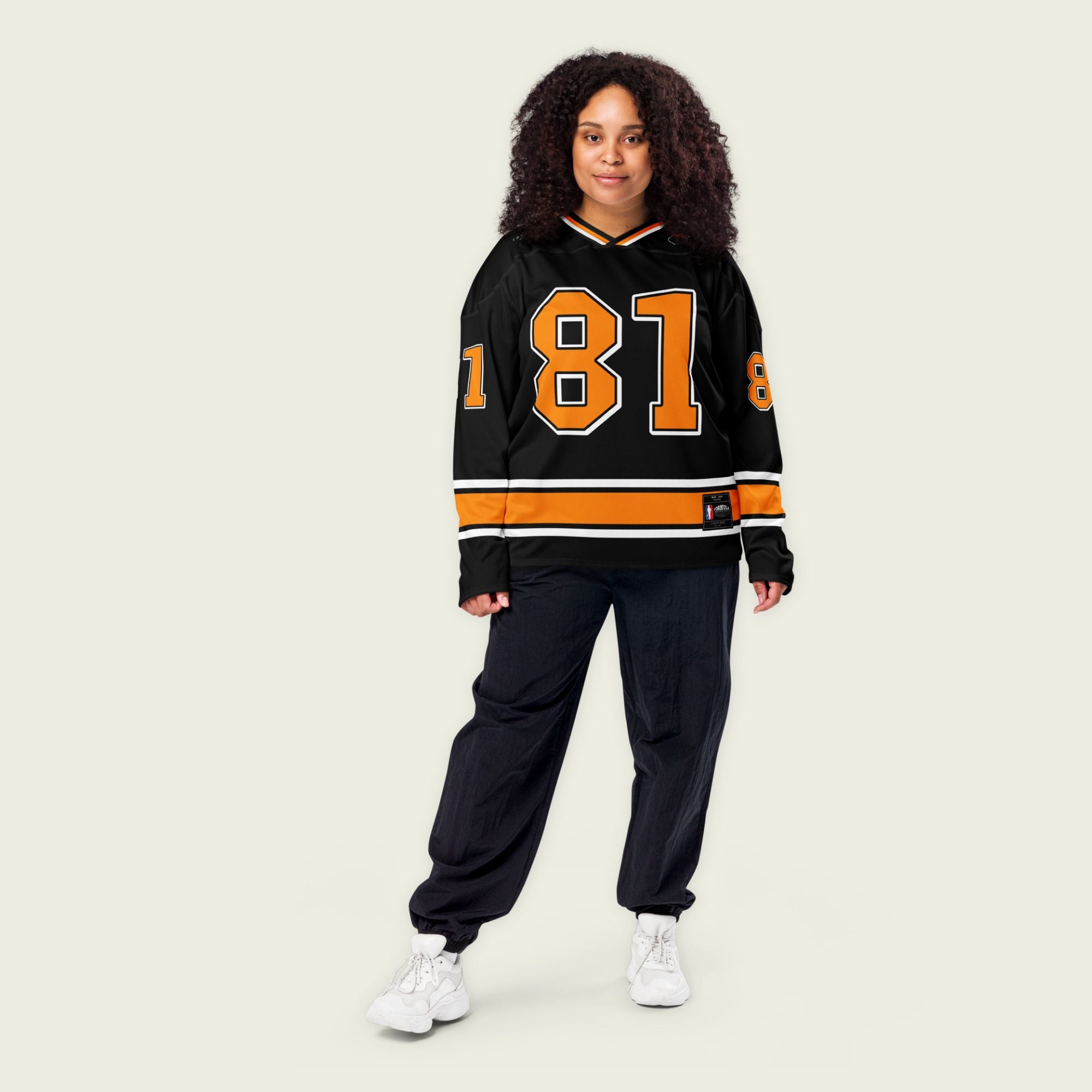 A black hockey jersey with Oscars piastri's McLaren F1 racing number 81 on the front and back in papaya orange, also the name Piastri is on the back in orange