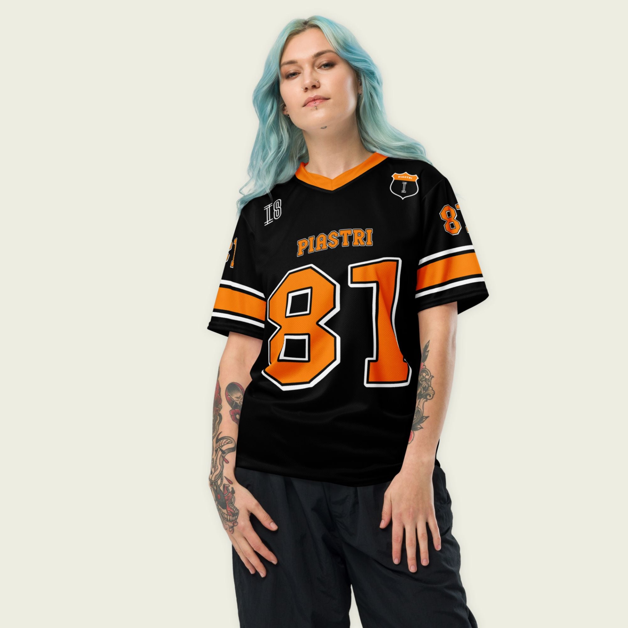 A black and papaya orange football jersey with Oscar Piastri McLaren F1 Racing number 81 in papaya orange on the front and back. The name Piastri is in orange on the front and back.