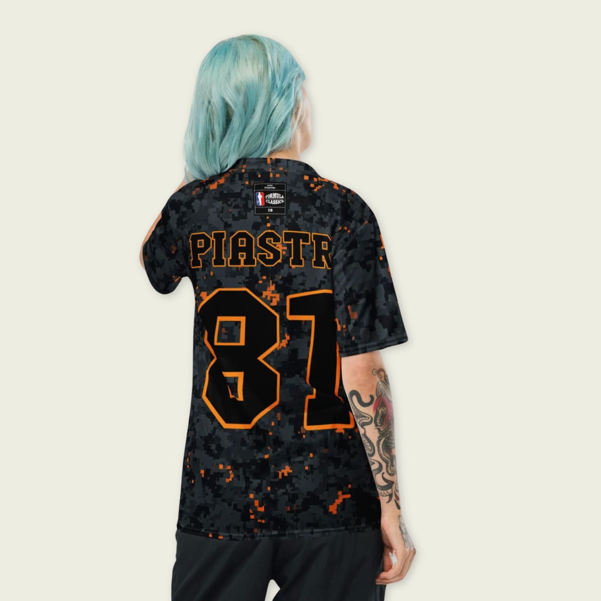 A camoflauge papaya orange football jersey with LOscar Piastri's McLaren F1 Racing number 81 on the front and back.