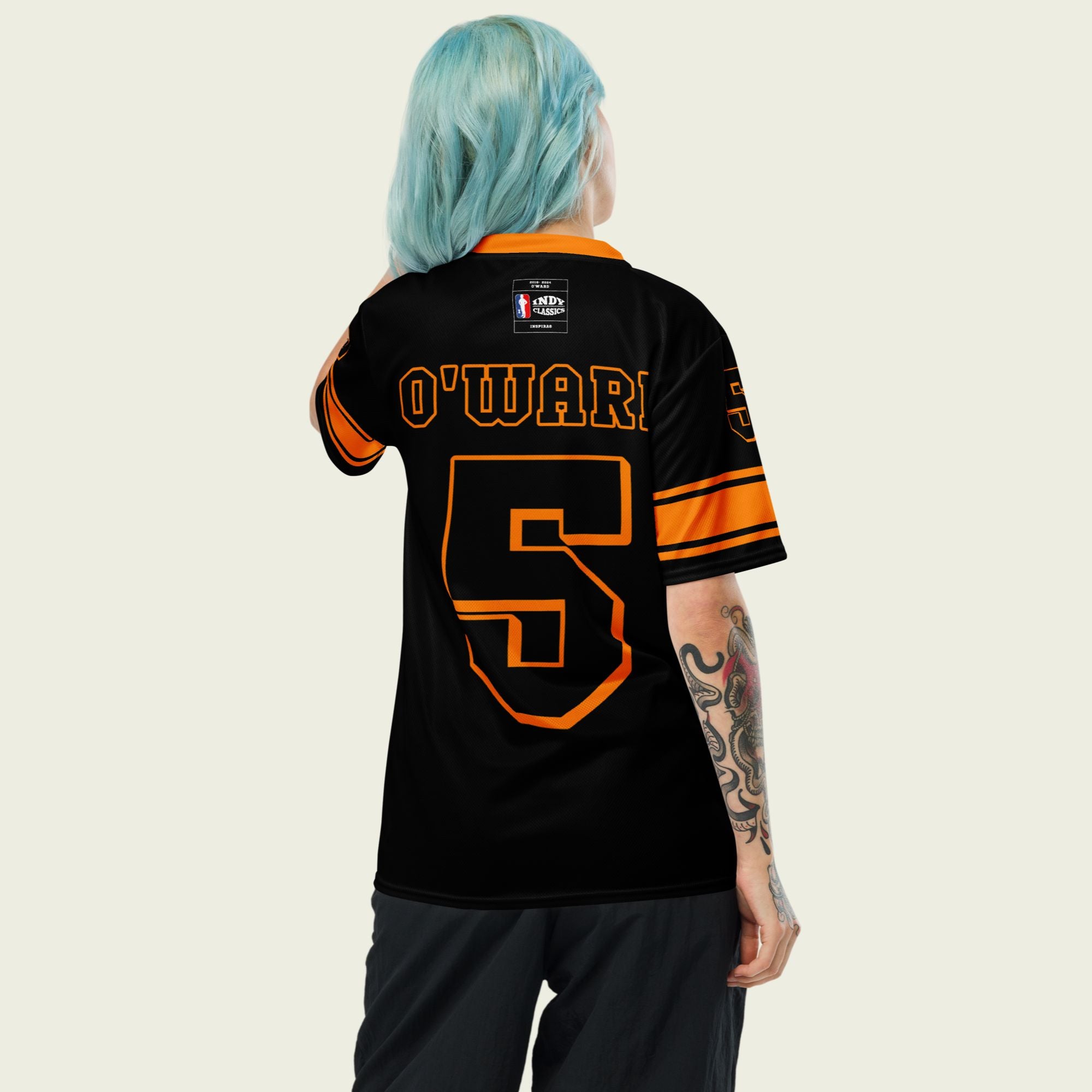 A black and orange football jersey with Pato O'Wards Arrow McLaren Indycar racing number 5 in orange. It has the name O'Ward on the front and back in orange as well.