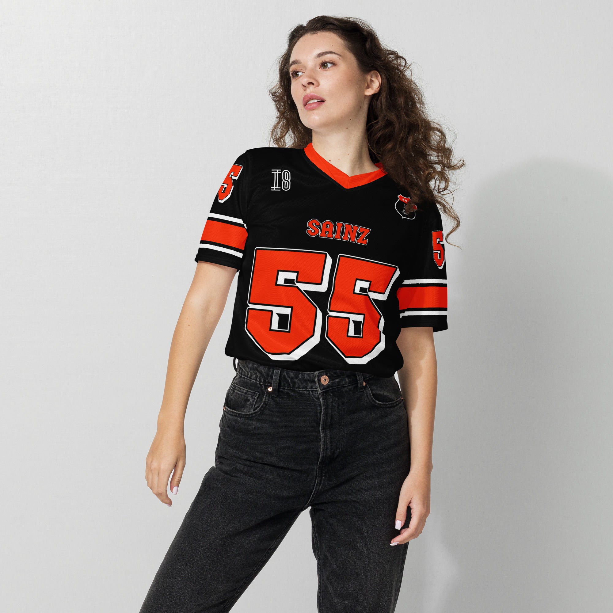 A black and red football jersey with Carlos Sainz Ferrari F1 racing number 55 in red. it has his name saizn on the front and back as well.