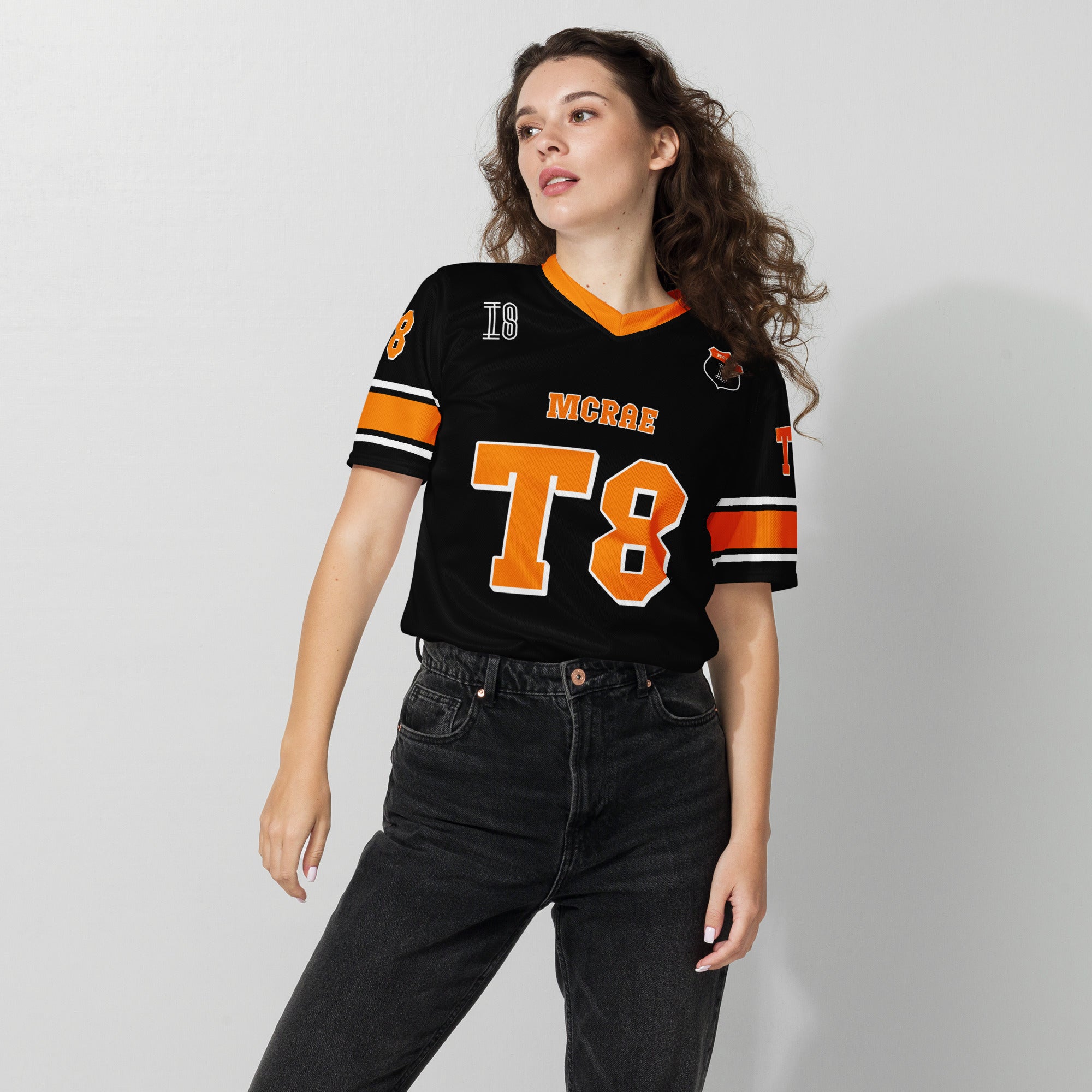A orange, black. and white football jersey with Tate Mcare on the back and front in orange with a white outline.