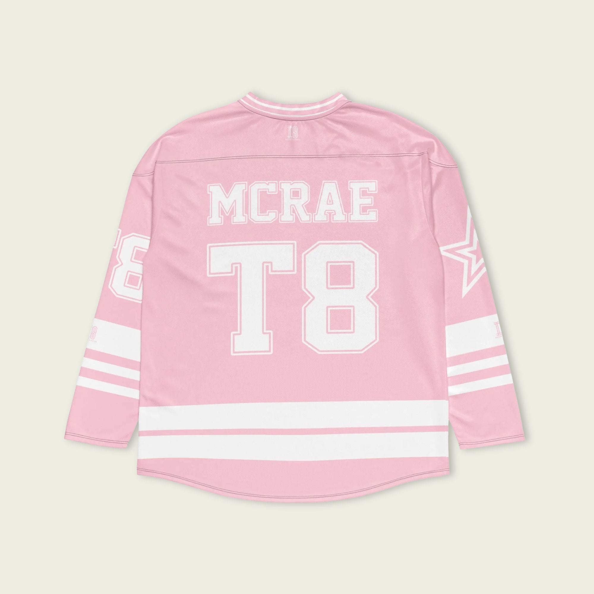 A pink and white hockey jersey with the name Mcrae in white on the front and back. Also T8 in white on the front and back.