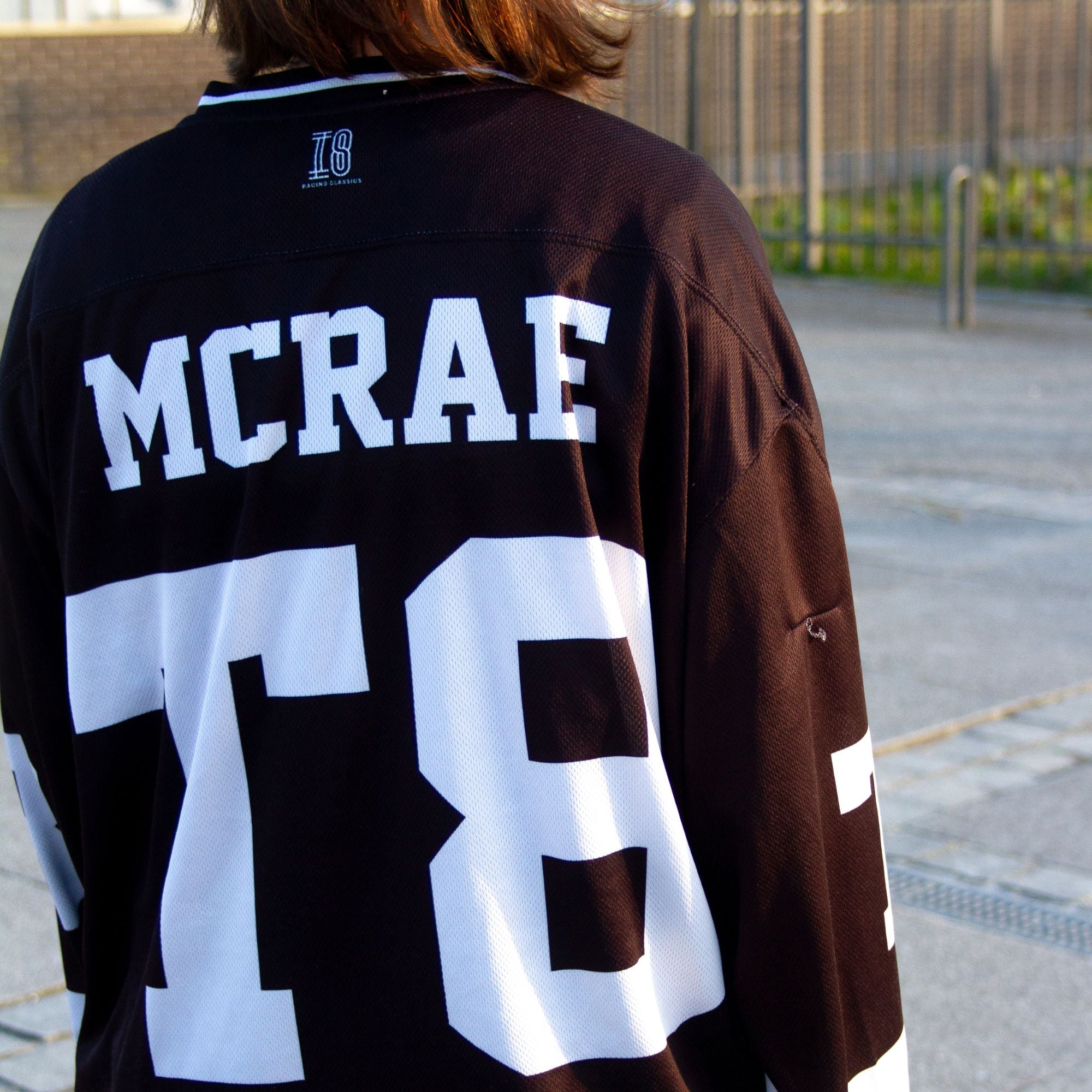 A black and white hockey jersey with the name Mcrae in white on the front and back. Also T8 in white on the front and back.