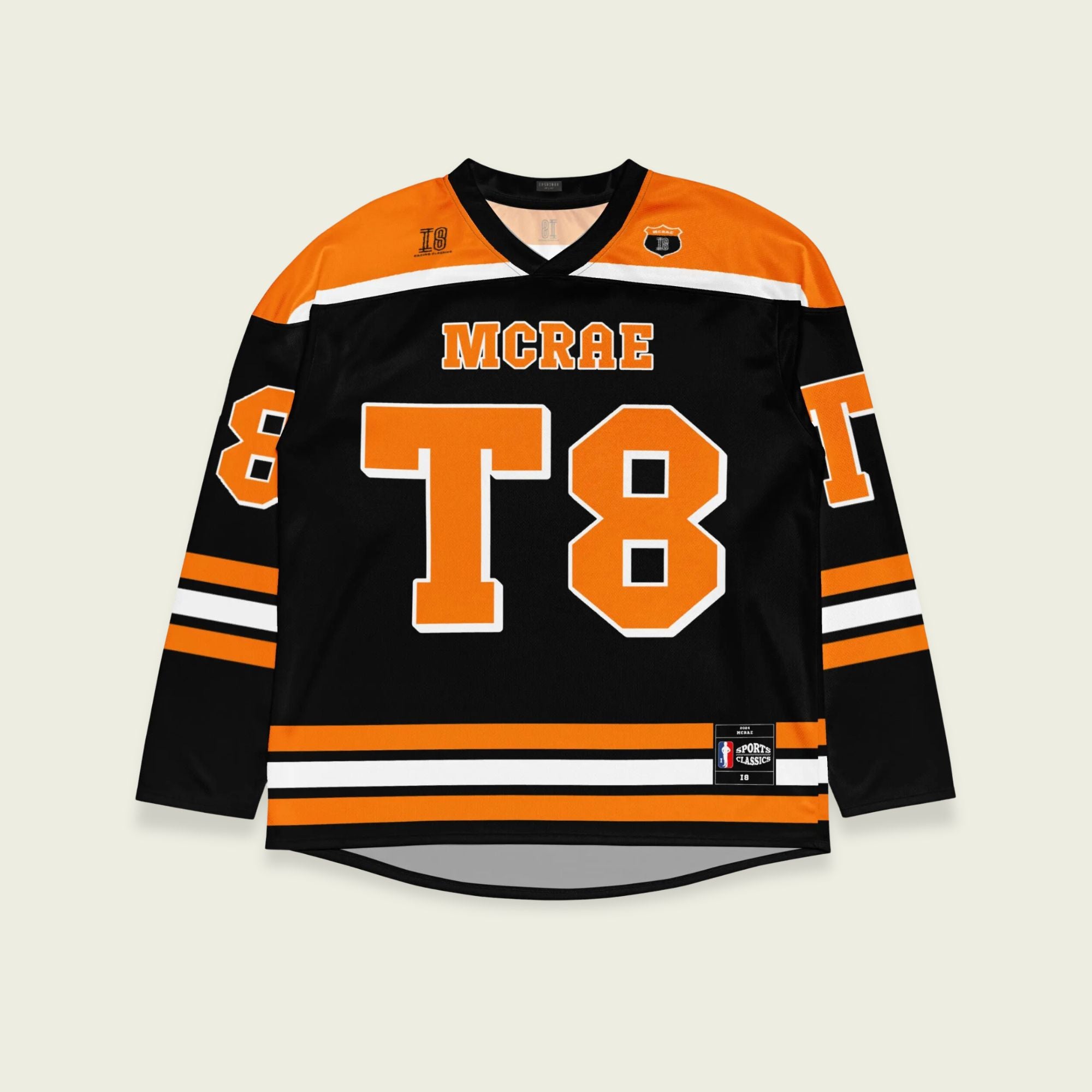 A black, orange, and white hockey jersey with the name Mcrae in orange on the front and back. Also T8 in orange on the front and back.