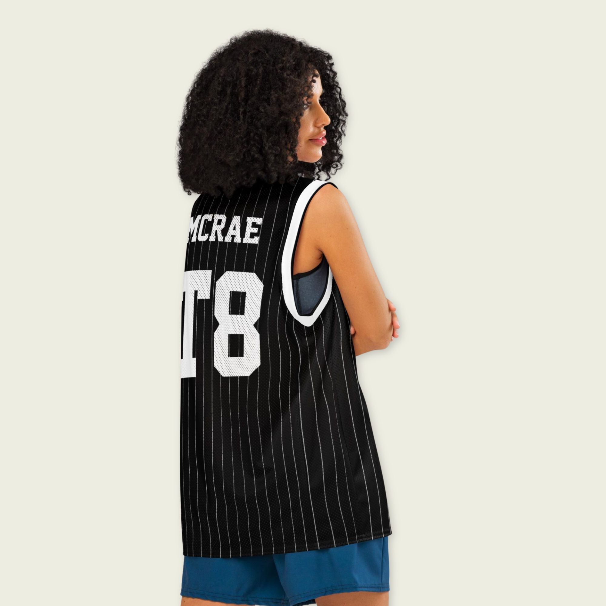 A black and white pin striped basketball Jersey with T8 Tate Mcrae on the front and back in white.