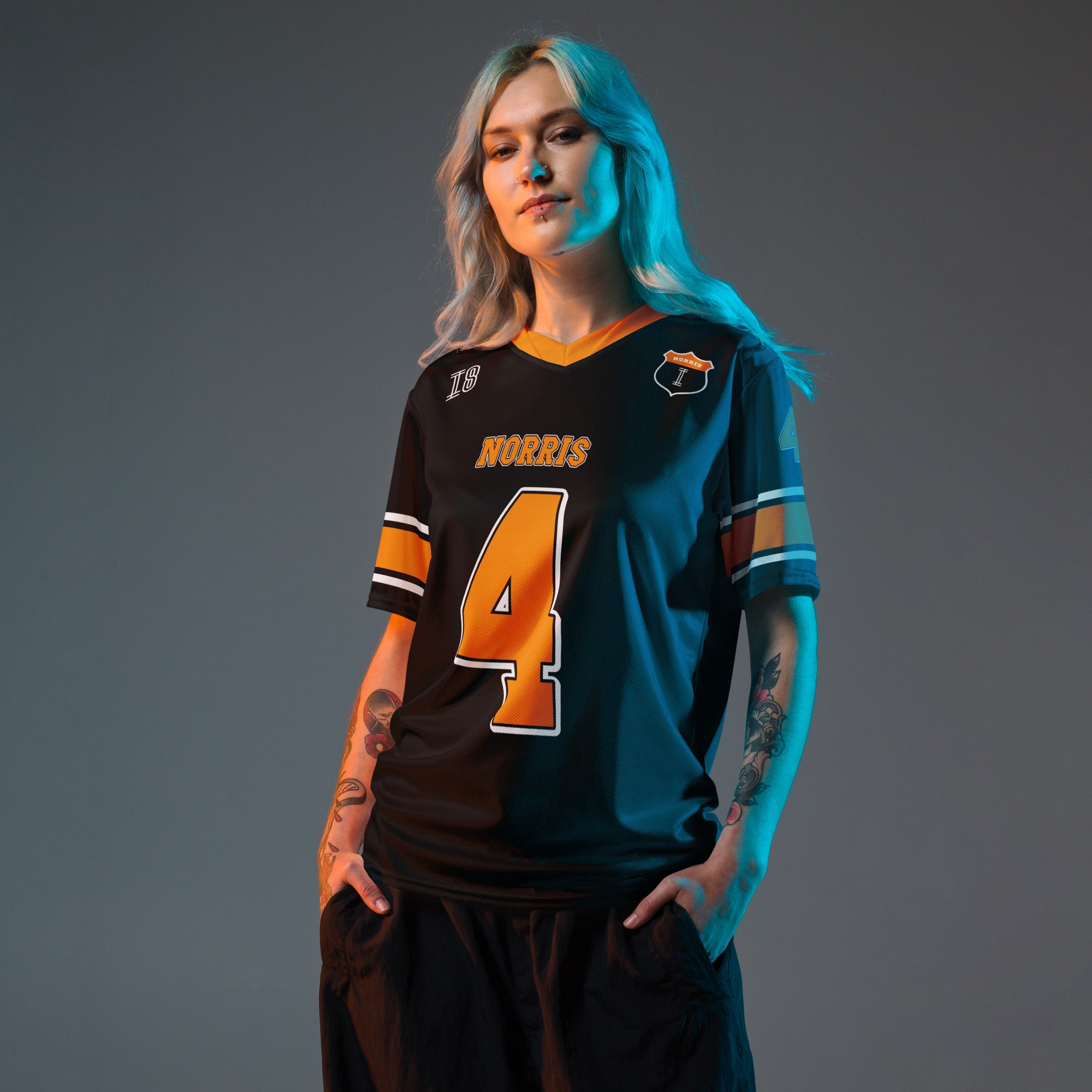 A black and Papaya orange football jersey with Lando Norris's McLaren F1 racing number 4 on the back and front in orange. It has the name Norris in papaya on the front and back as well.