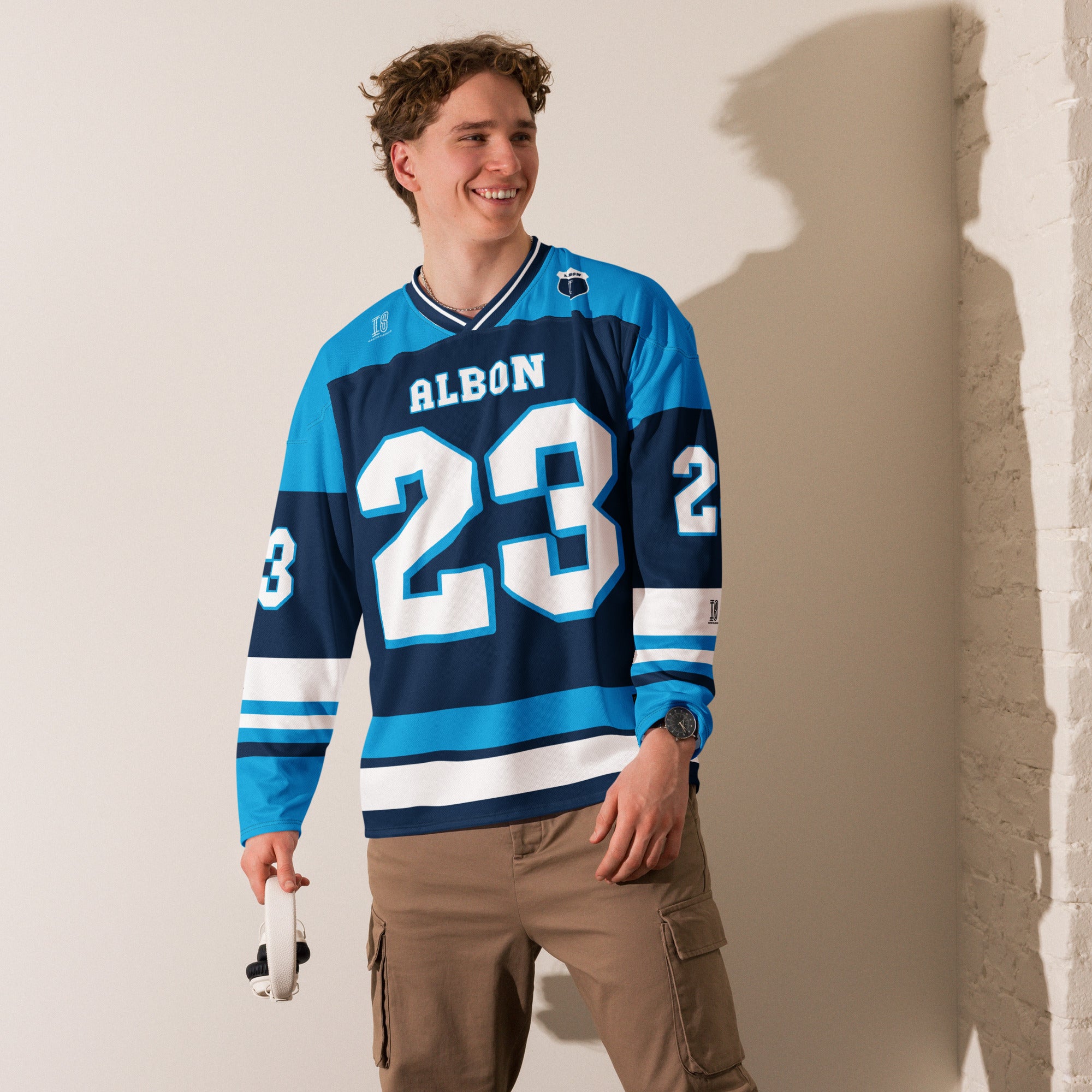 A blue hockey jersey with Alex Albon's Williams F1 racing number 23 on the front and back in white, also the name Albon is on the back and front in White.
