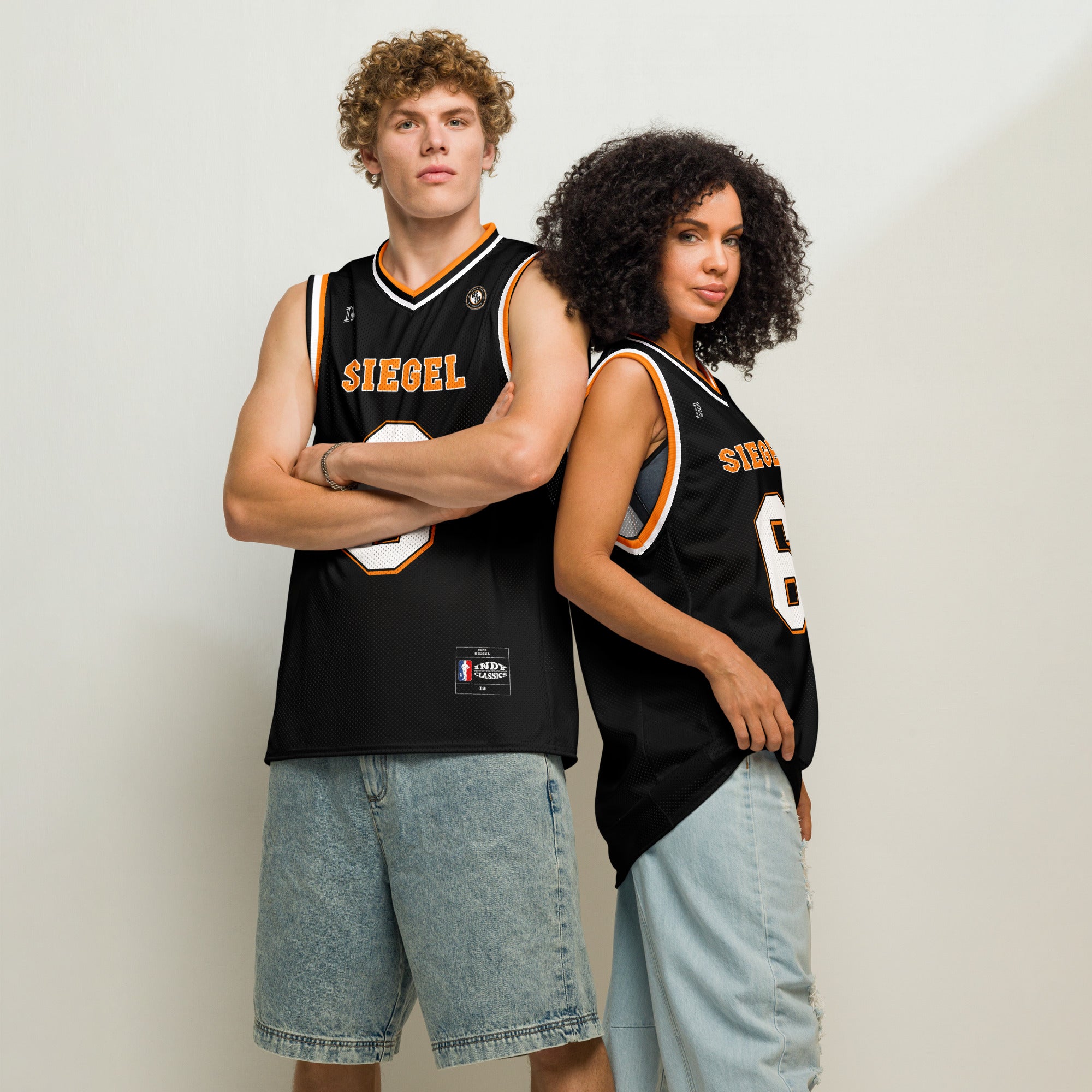 Two people wearing black basketball jerseys with 'SIEGEL' branding on a plain background
