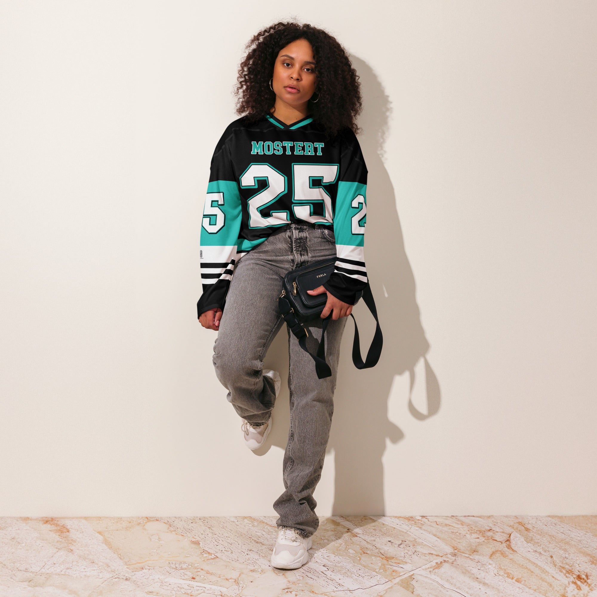 Person wearing a black and teal sports jersey with the number 25, standing against a plain background.