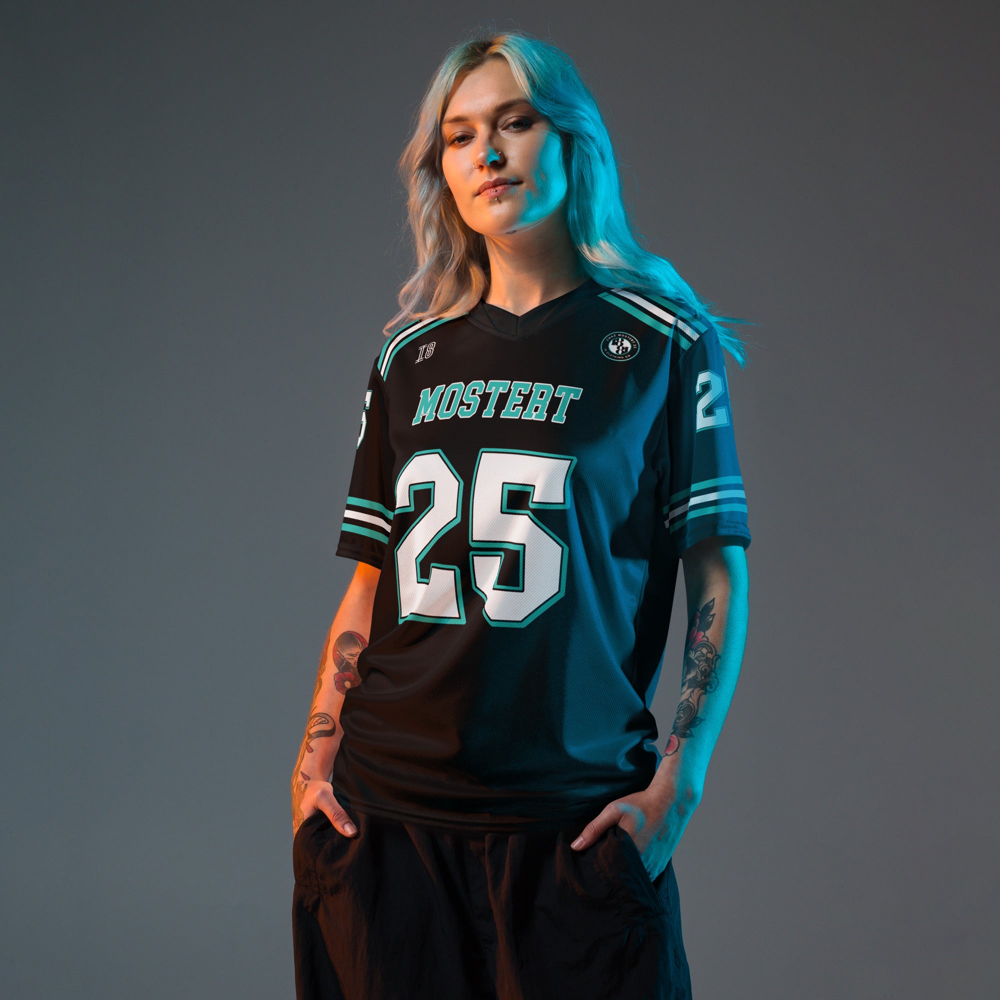 Person wearing a black sports jersey with teal and white details on a gray background