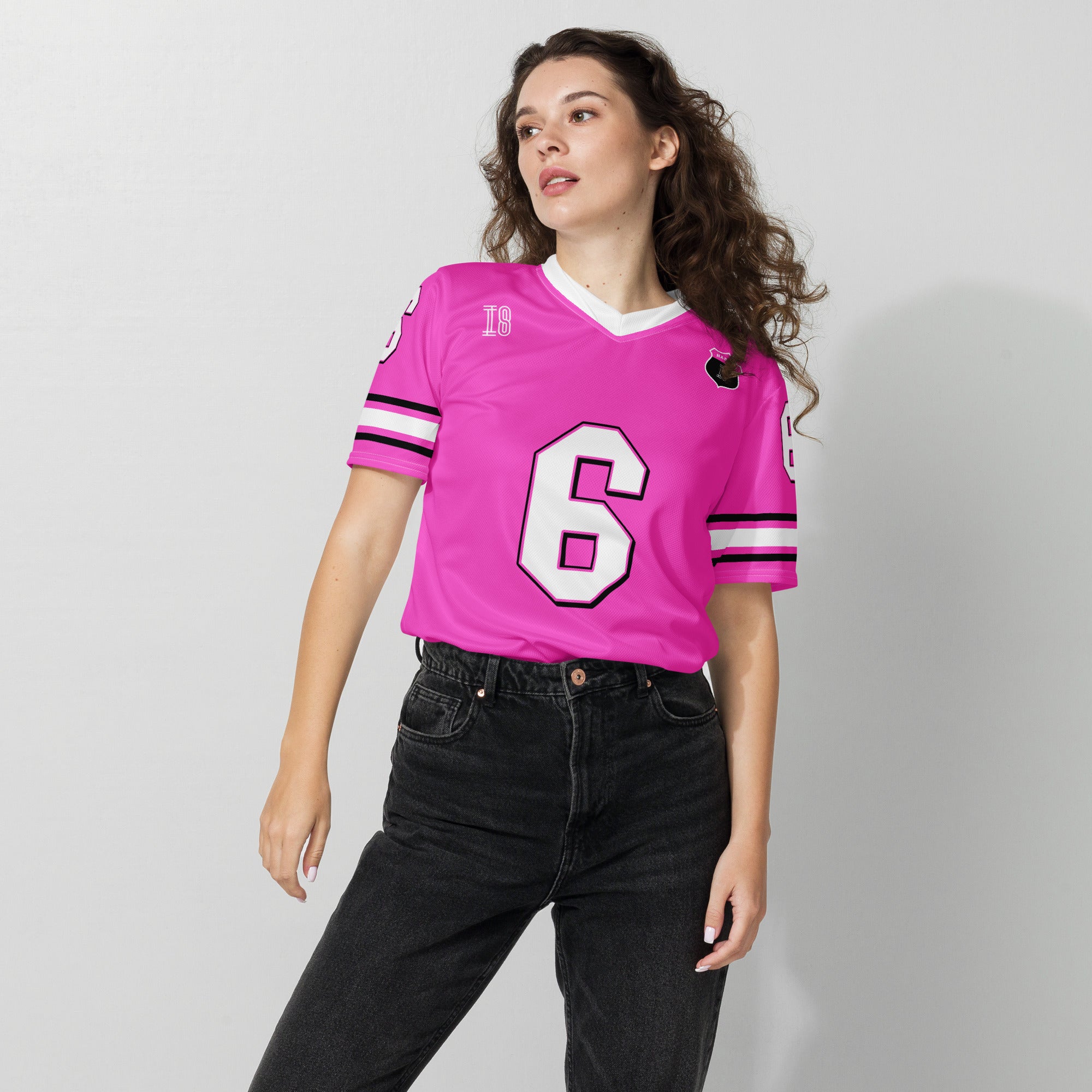 Person wearing a pink sports jersey with the number 6 on a plain background