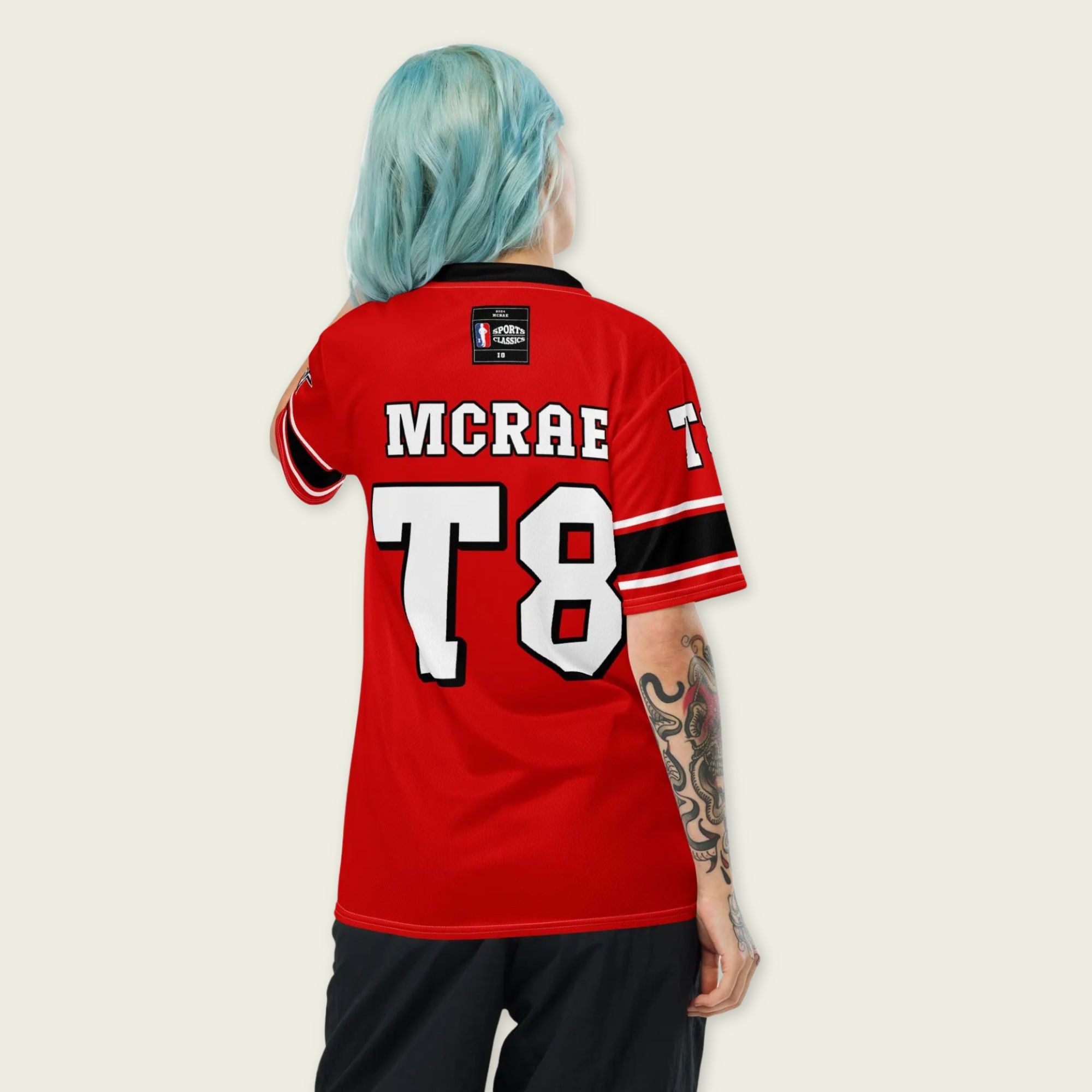 A red, black, and white football jersey with Tate Mcare on the back and front in white with a white outline.