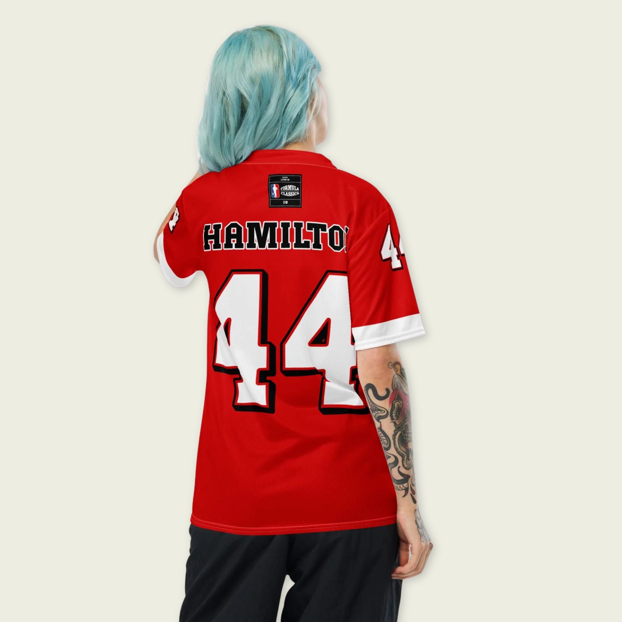 A red and white football jersey with Lewis Hamilton's Ferrari  F1 racing number 44 on the back and front in white. It has the name Hamilton in red on the front and back as well.