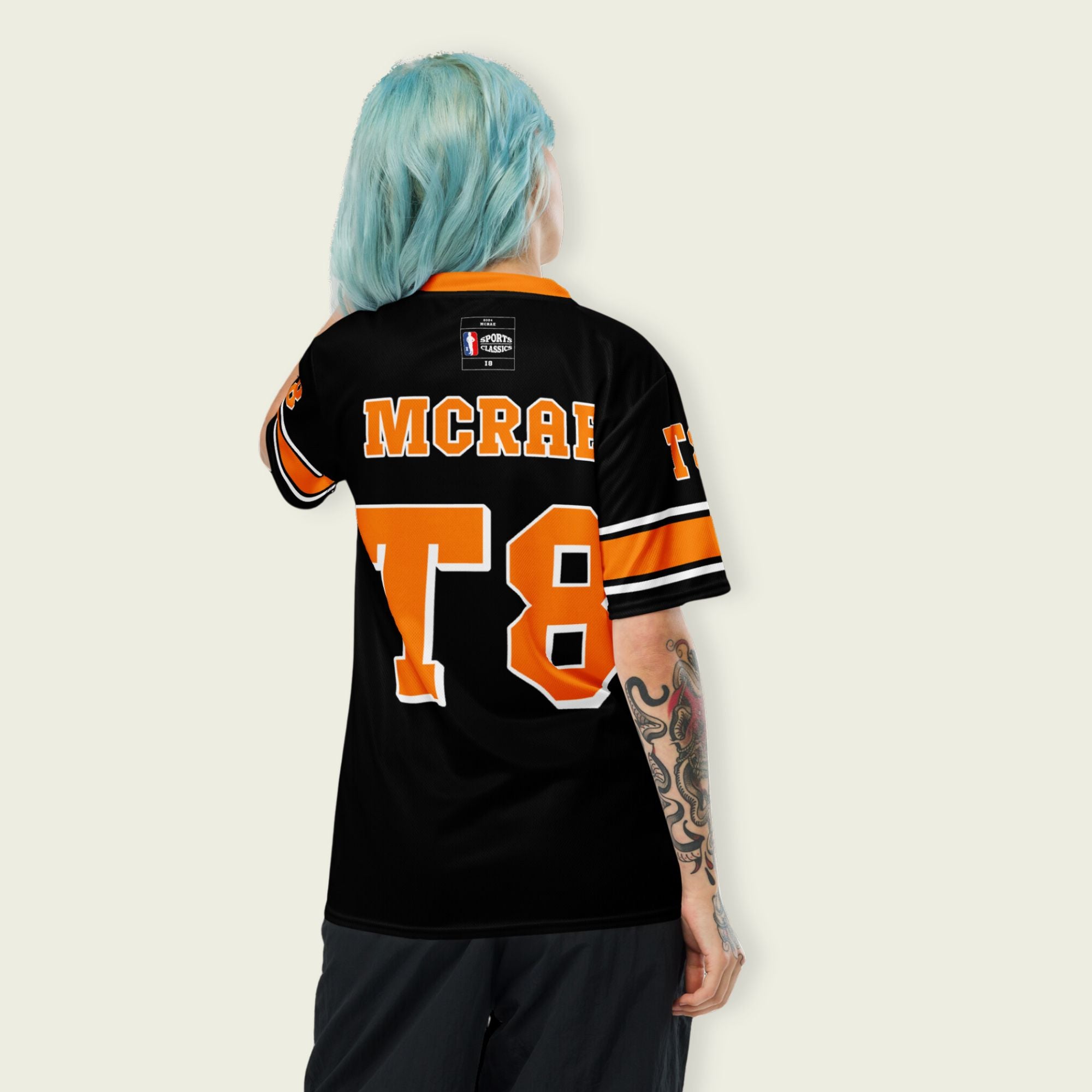 A orange, black. and white football jersey with Tate Mcare on the back and front in orange with a white outline.