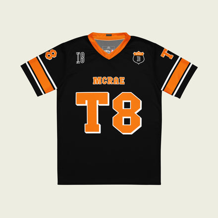 A orange, black. and white football jersey with Tate Mcare on the back and front in orange with a white outline.