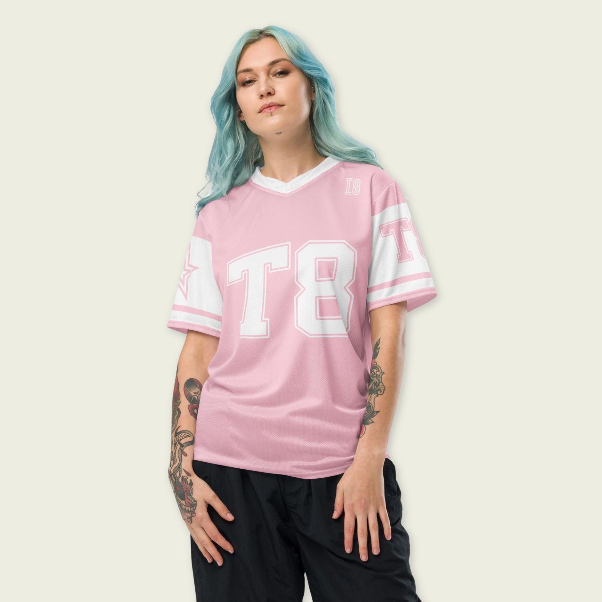 A pink and white football jersey with Tate Mcare on the back and front in white with a white outline.