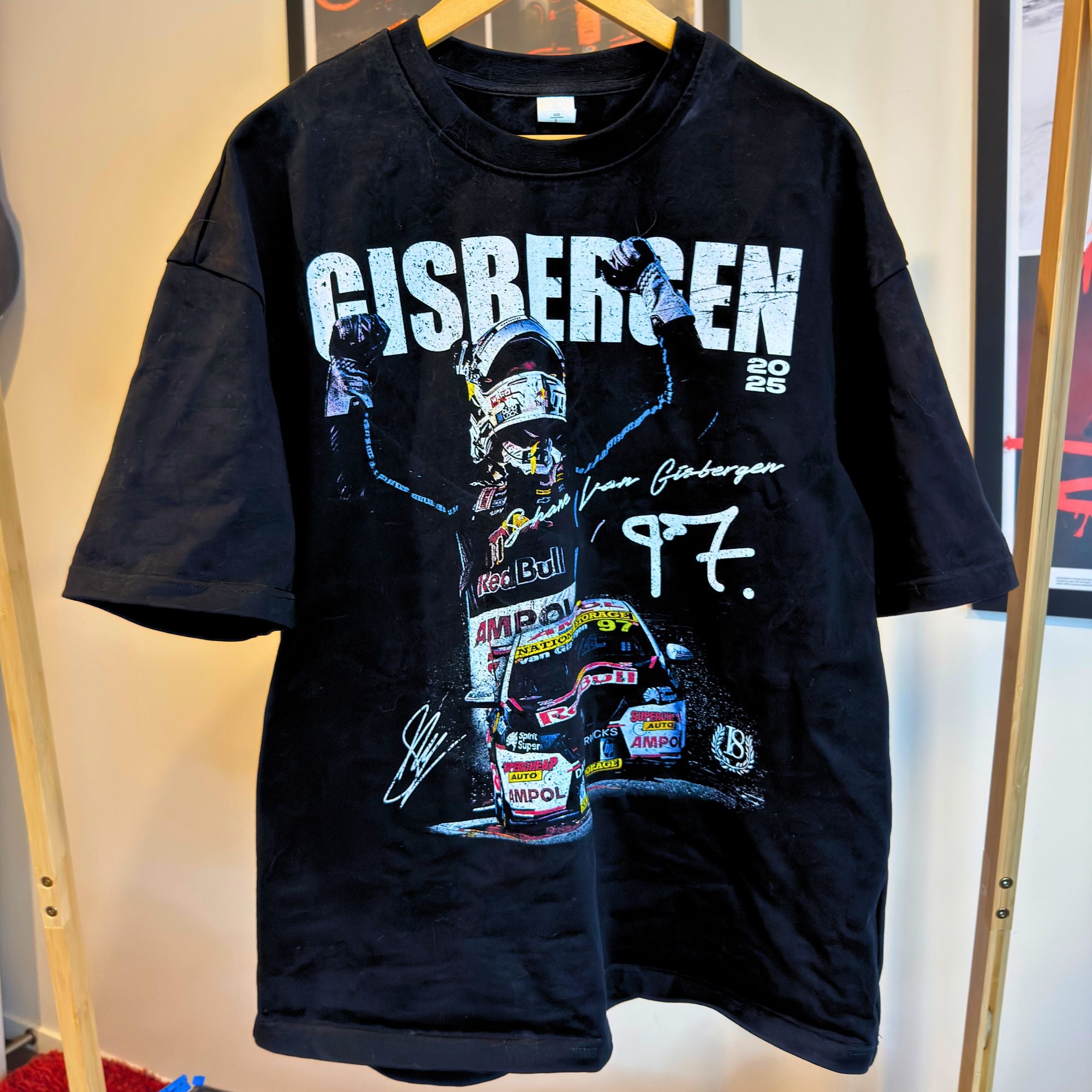 Black t-shirt with a graphic of a racing driver and 'Gisbergen' branding on a hanger.