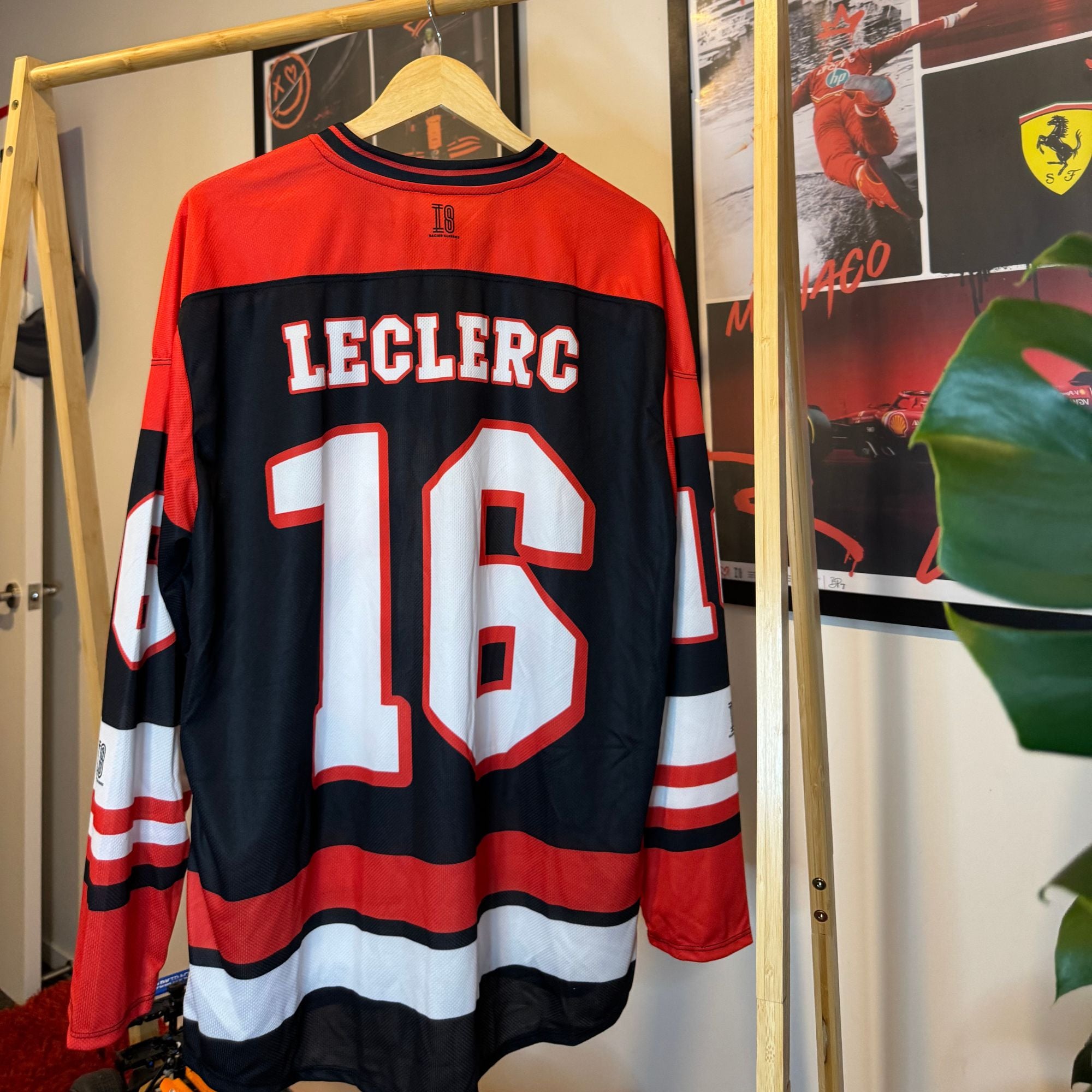 Hockey jersey with 'LECLERC' and number '16' on a hanger against a wall with posters.