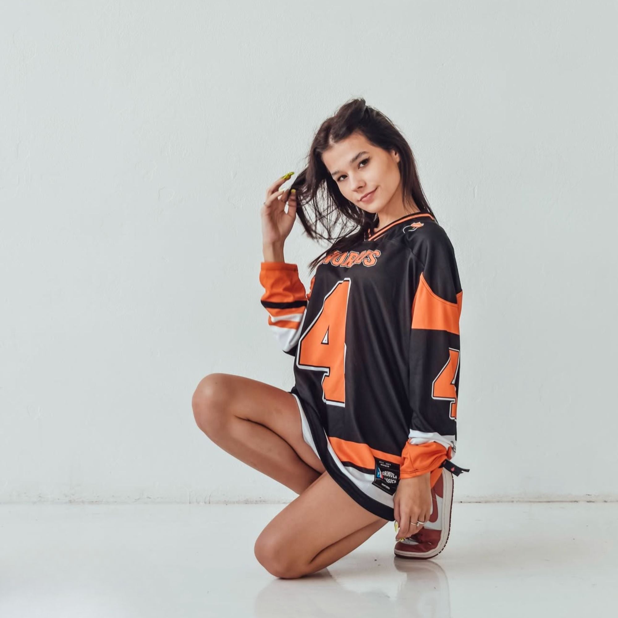 A black hockey jersey with Lando Norris mclaren F1 racing number 4 on the front and back in papaya orange, also the name norris is on the back and front in orange