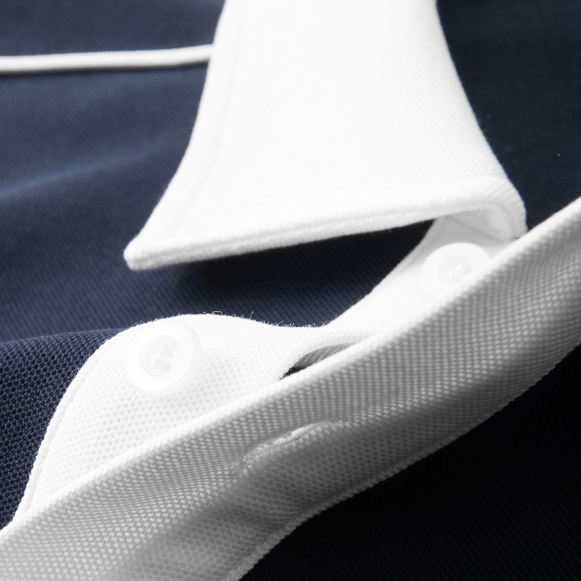 Close-up of a white shirt collar with a navy background