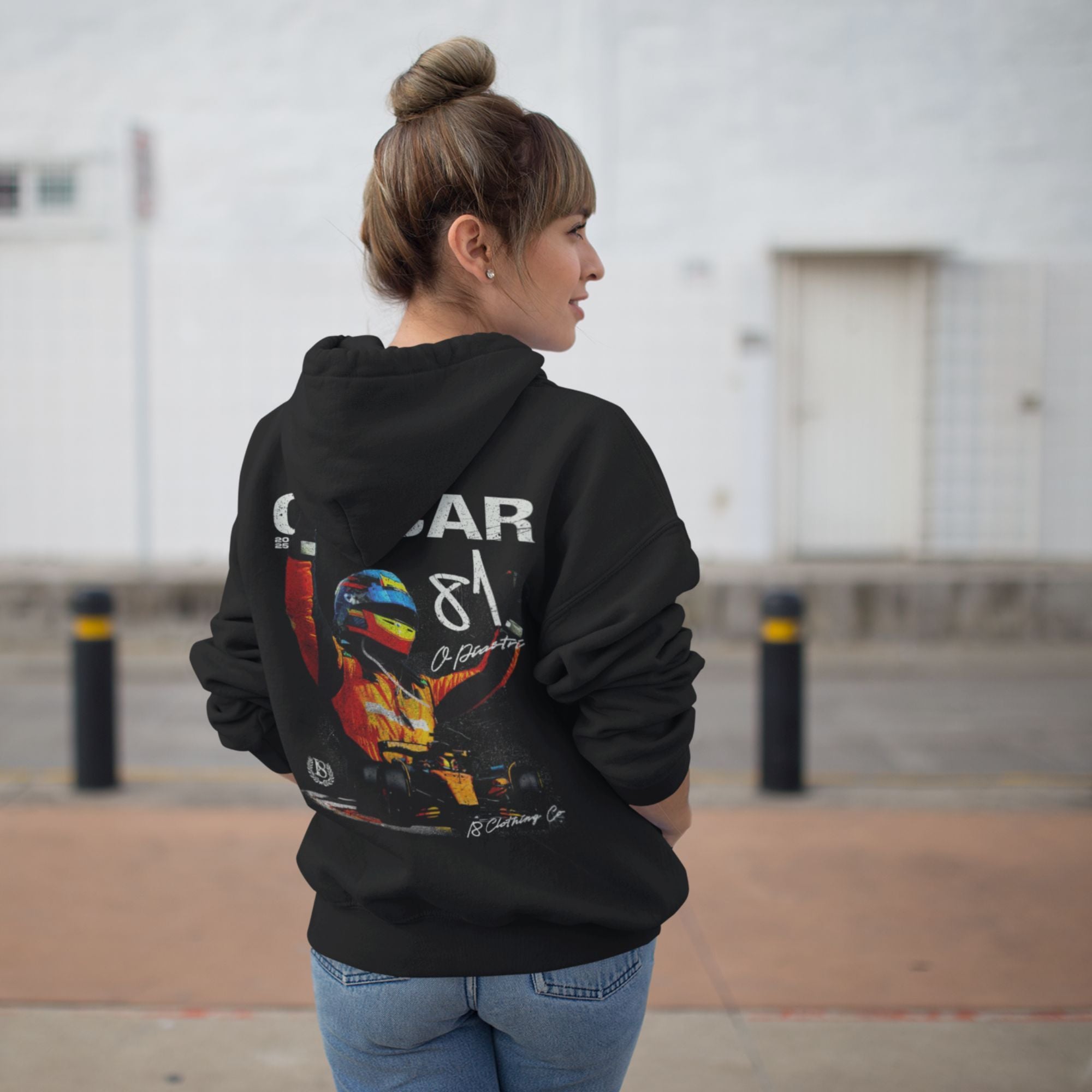 Person wearing a black hoodie with colorful graphic on the back, standing outdoors.