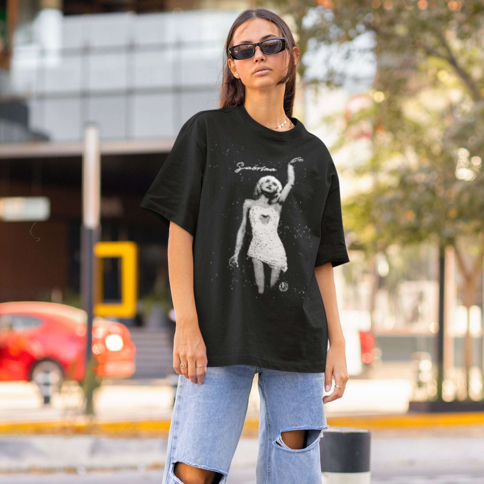 Person wearing a black t-shirt with a graphic design outdoors