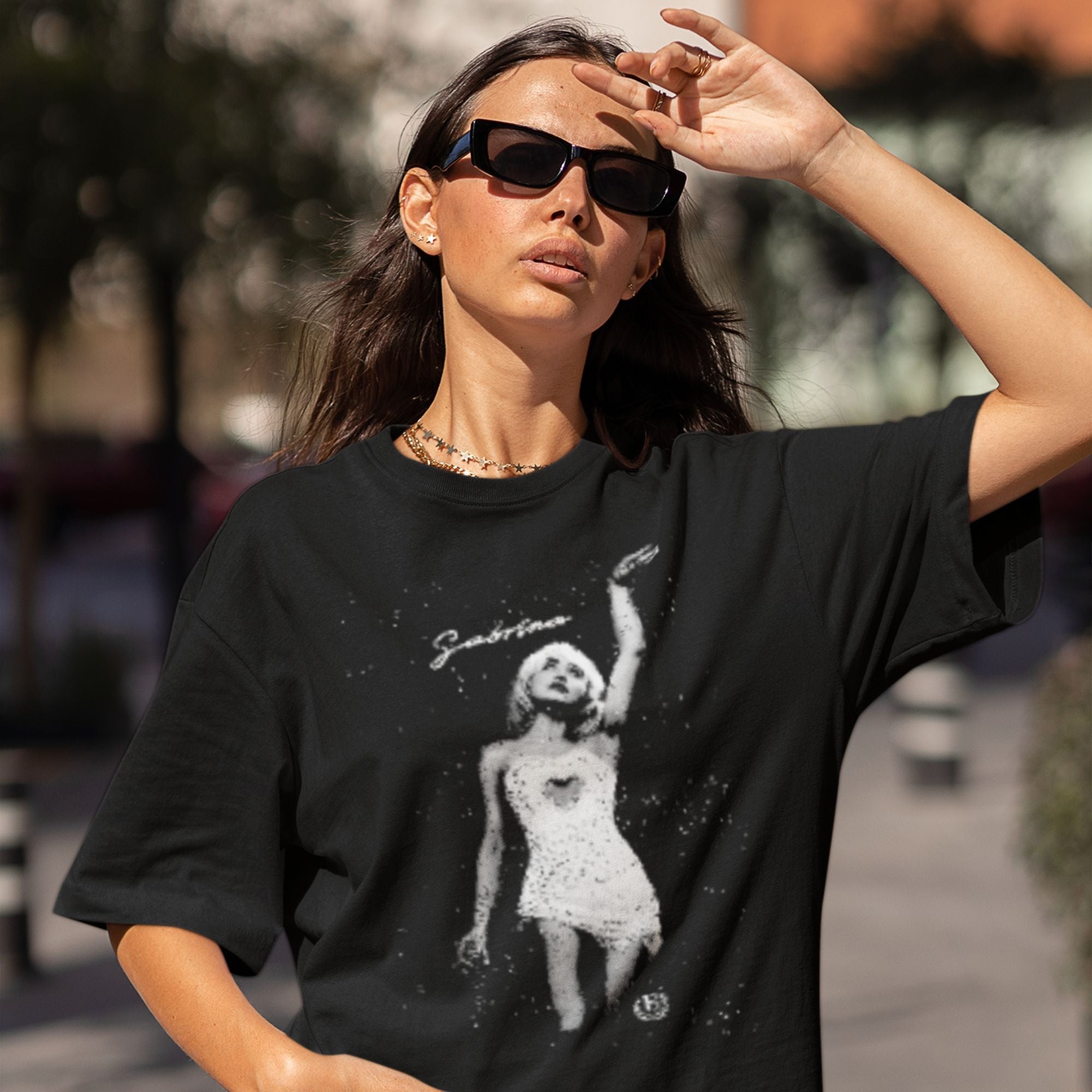 Woman wearing a black t-shirt with a graphic design outdoors