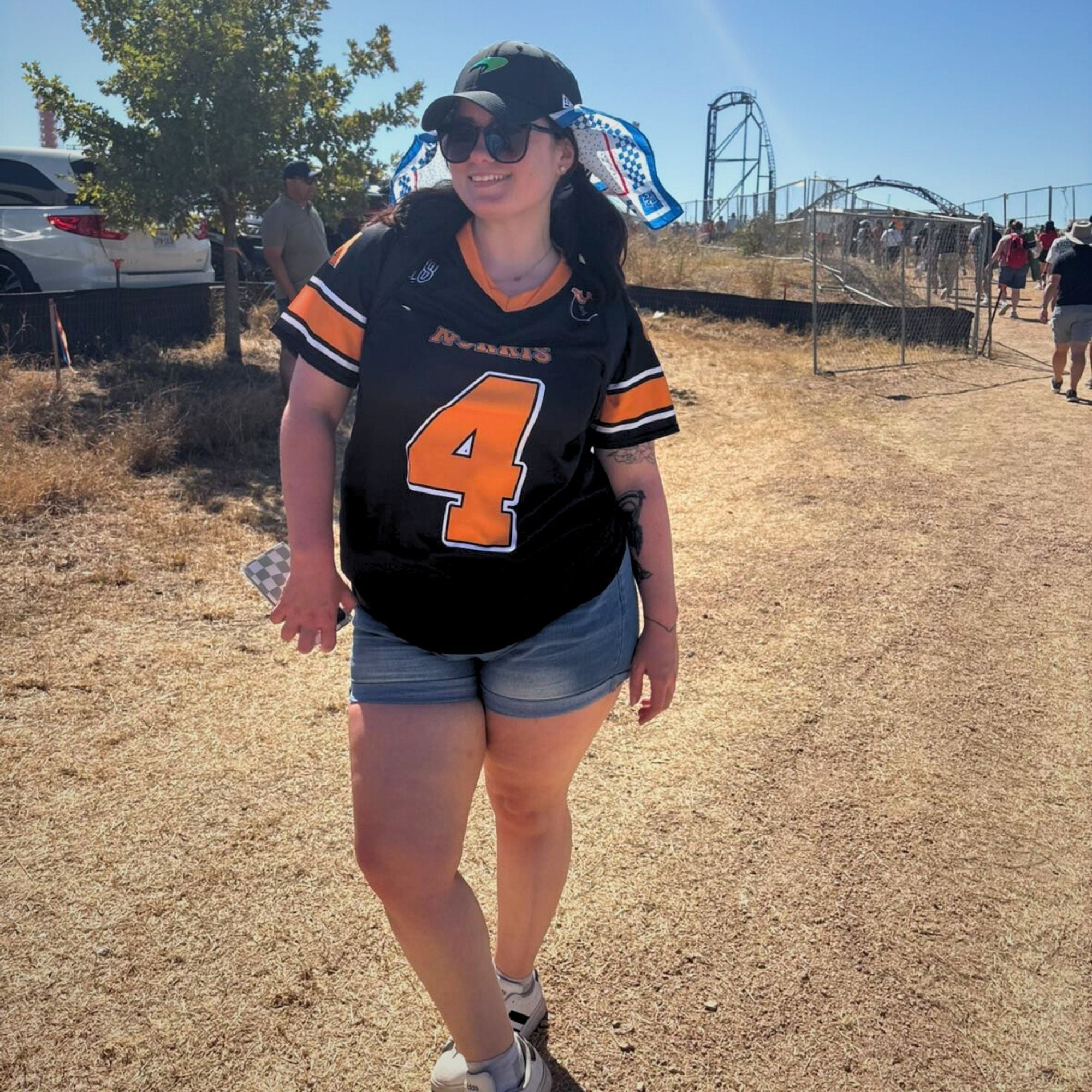 Person wearing a black and orange sports jersey with number 4, standing outdoors.