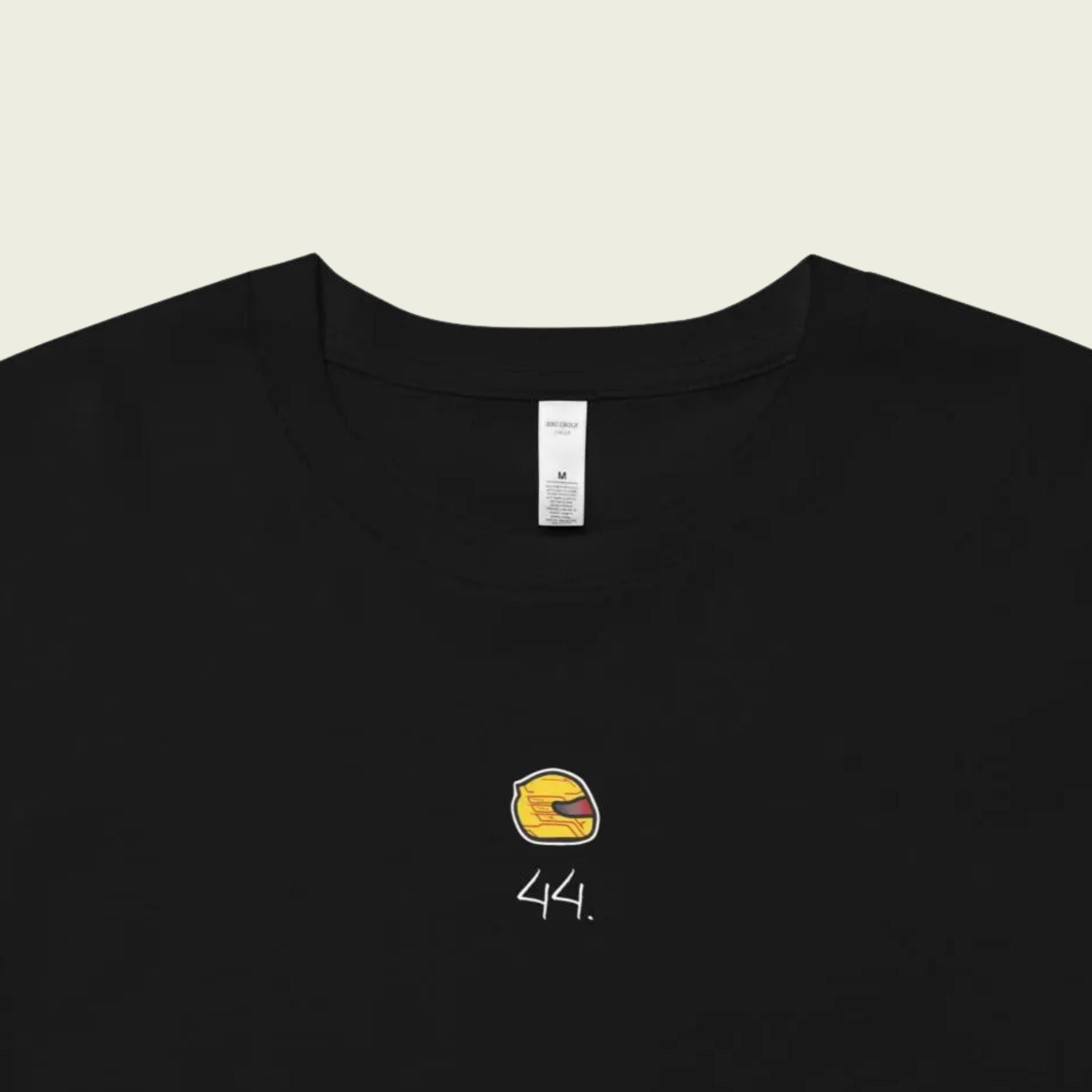 Black t-shirt with a yellow and white logo on a beige background