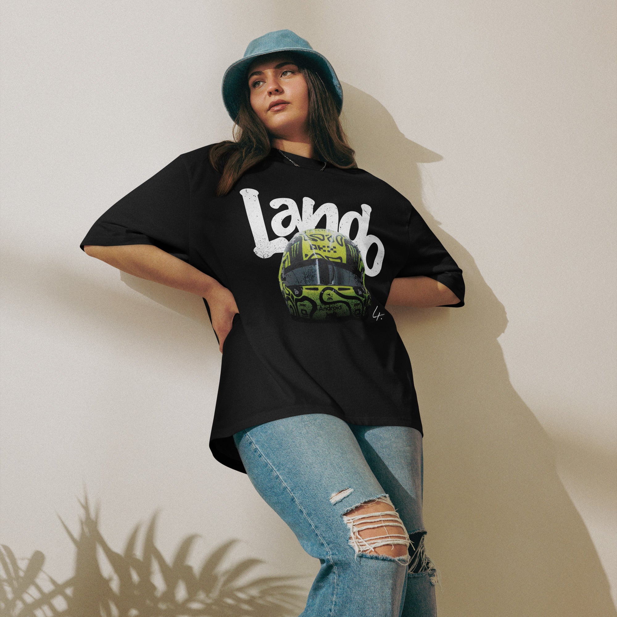 A black oversized TShirt with white text Lando on the front  and lando norris's neon green helmut on the front.