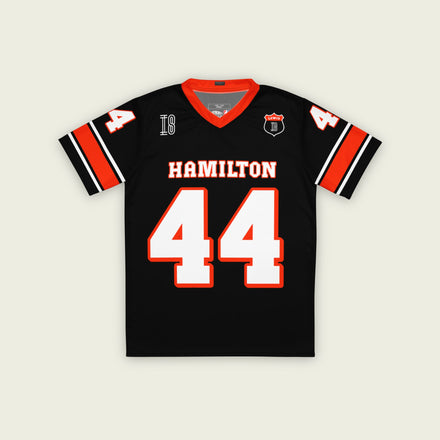 A black and red football jersey with Lewis Hamilton's Ferrari  F1 racing number 44 on the back and front in white. It has the name Hamilton in red on the front and back as well.