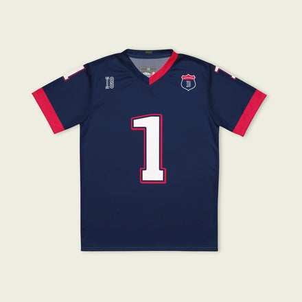 A navy blue and red football jersey with Max Verstappen's Redbull  F1 racing number 1 on the back and front in white. It has the name Verstappen in white on the front and back as well.
