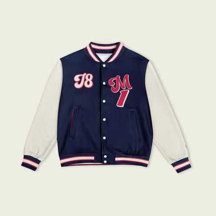 A navy blue, tan, and red varsity jacket with Max Verstappen Redbull F1 racing number in red on the front and back.