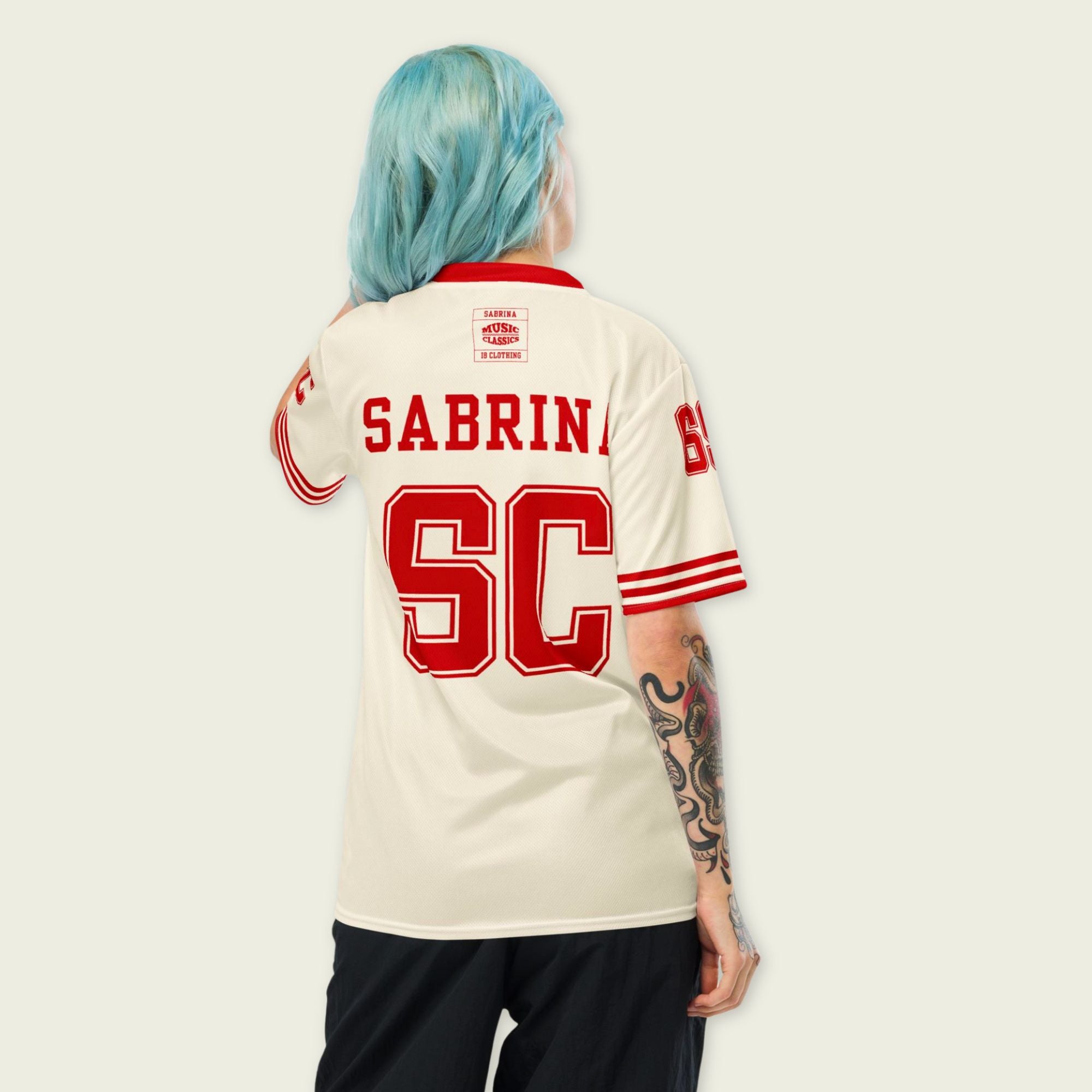 Person wearing a white sports jersey with red lettering and numbers on a plain background