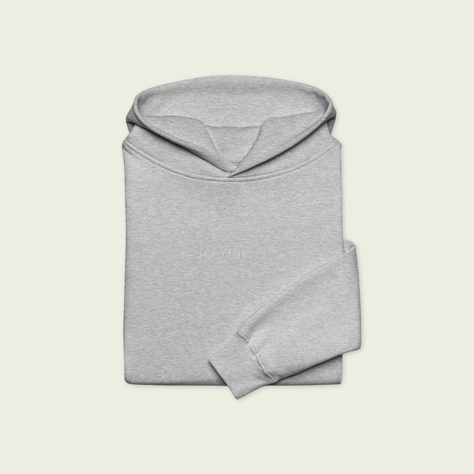 Folded gray hoodie on a light beige background