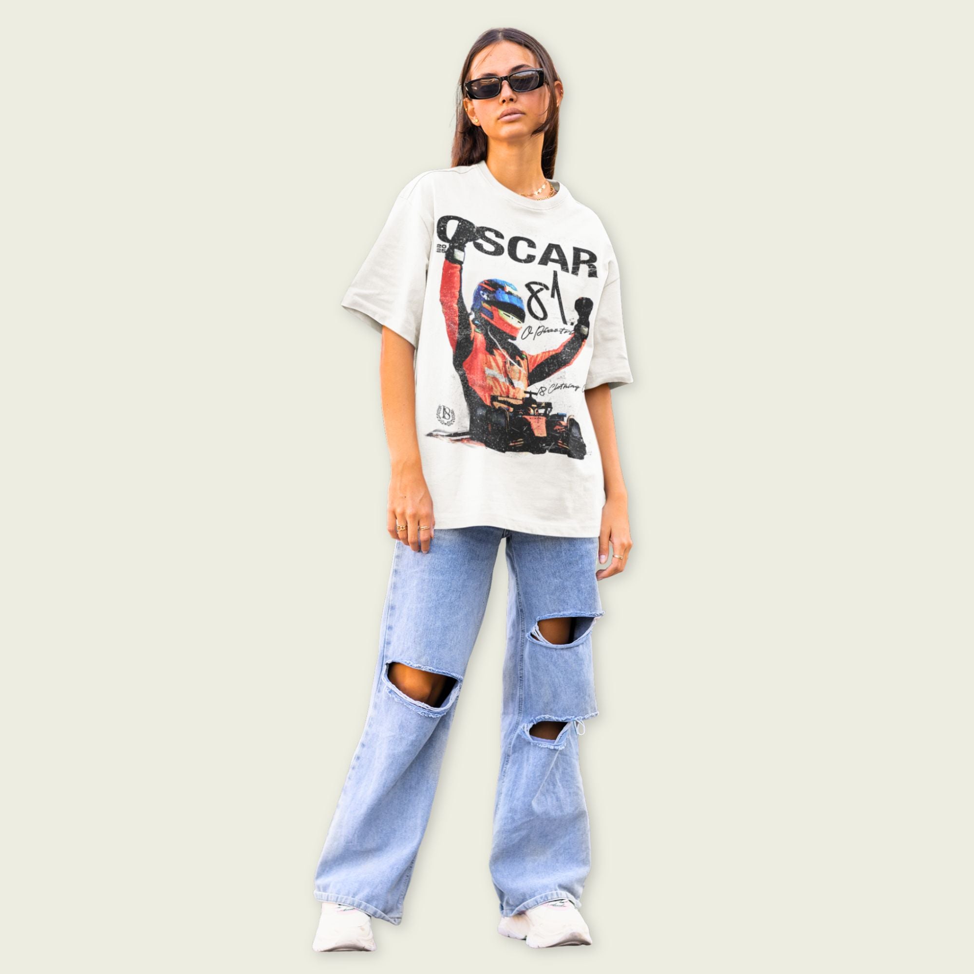 Person wearing a graphic t-shirt and ripped jeans on a plain background
