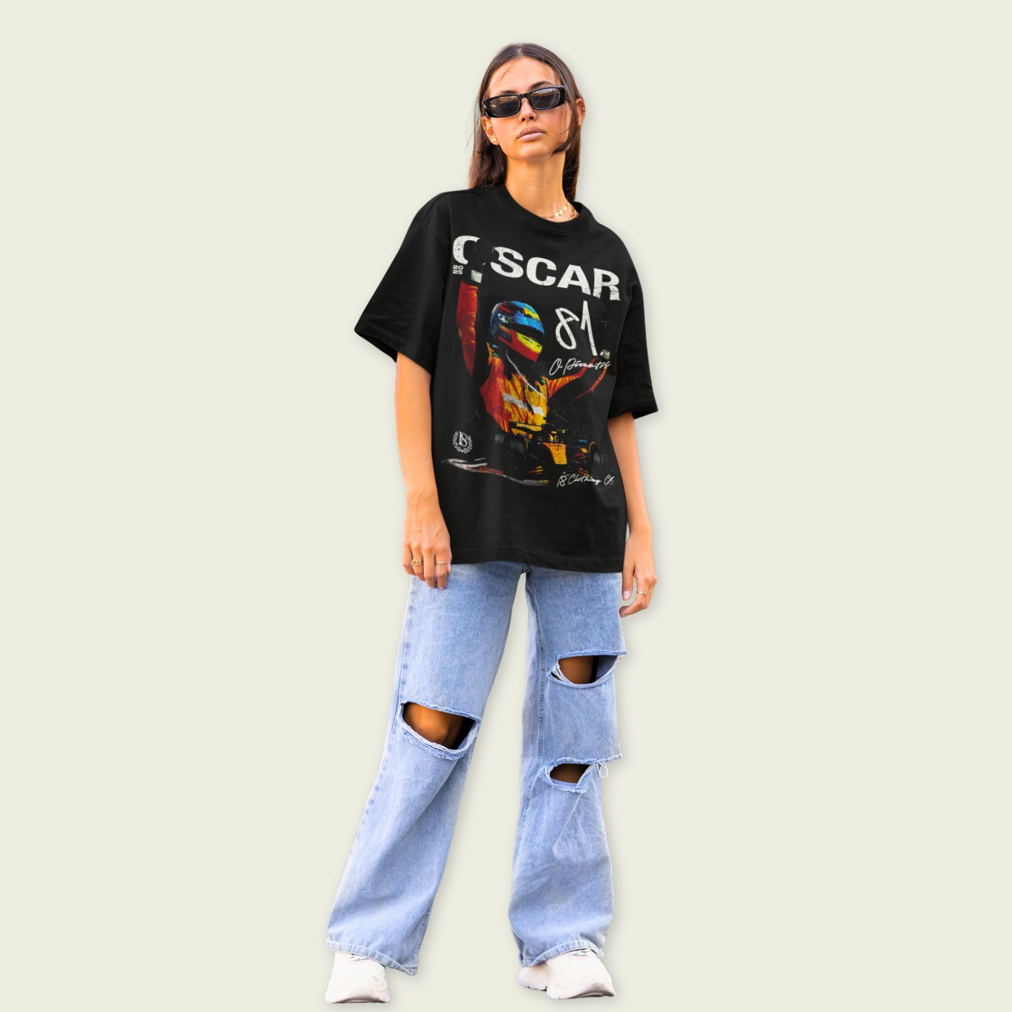Person wearing a black graphic t-shirt and ripped jeans on a plain background
