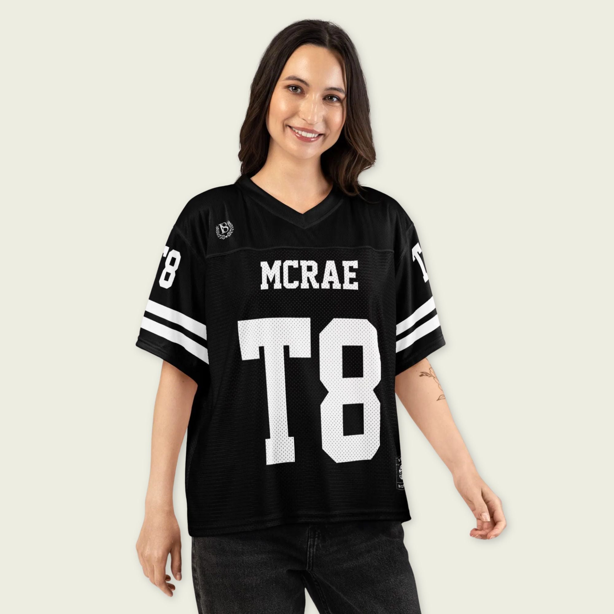 Woman wearing a black sports jersey with 'MCRAE' and 'T8' printed on it against a plain background