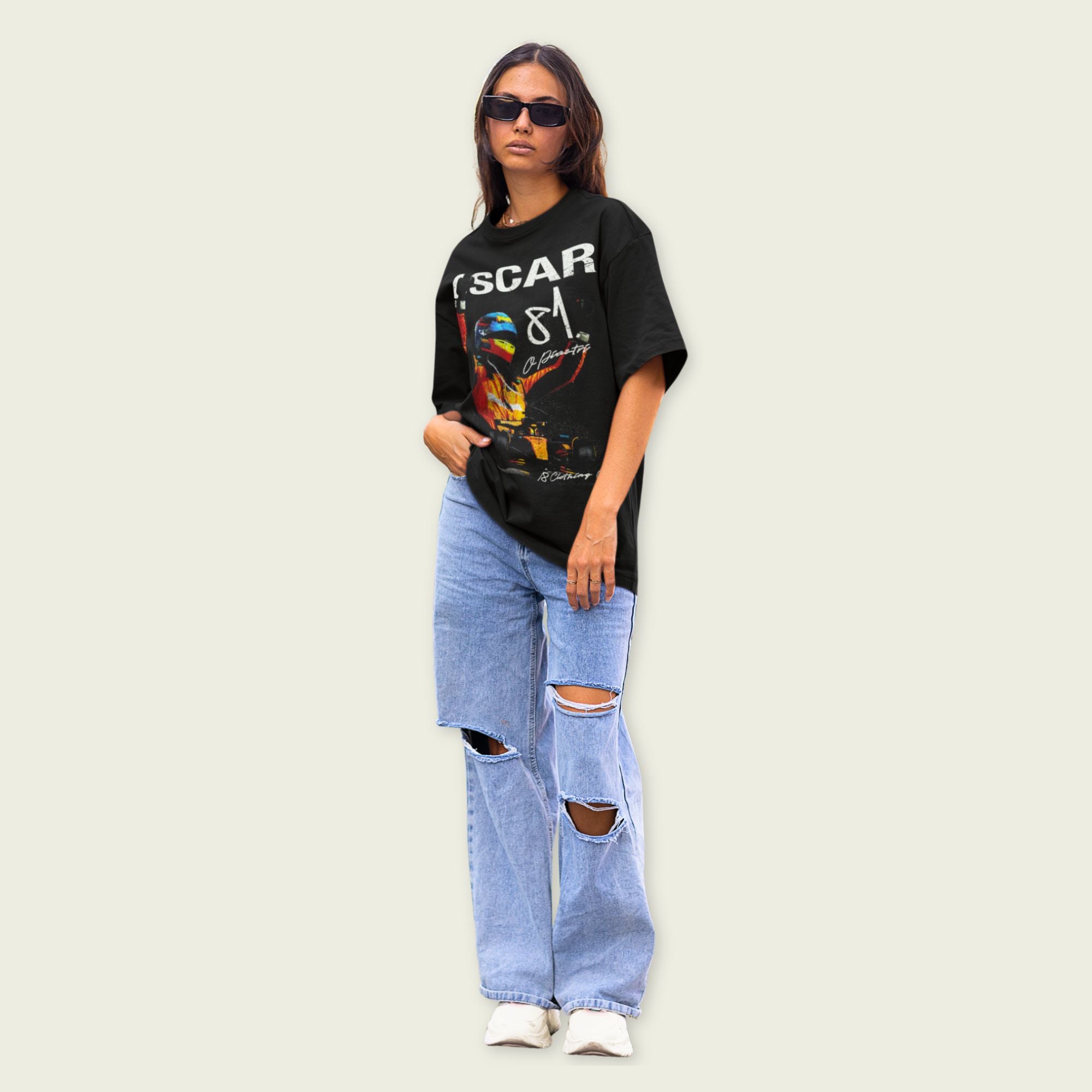 Person wearing a black graphic t-shirt and ripped jeans on a light background