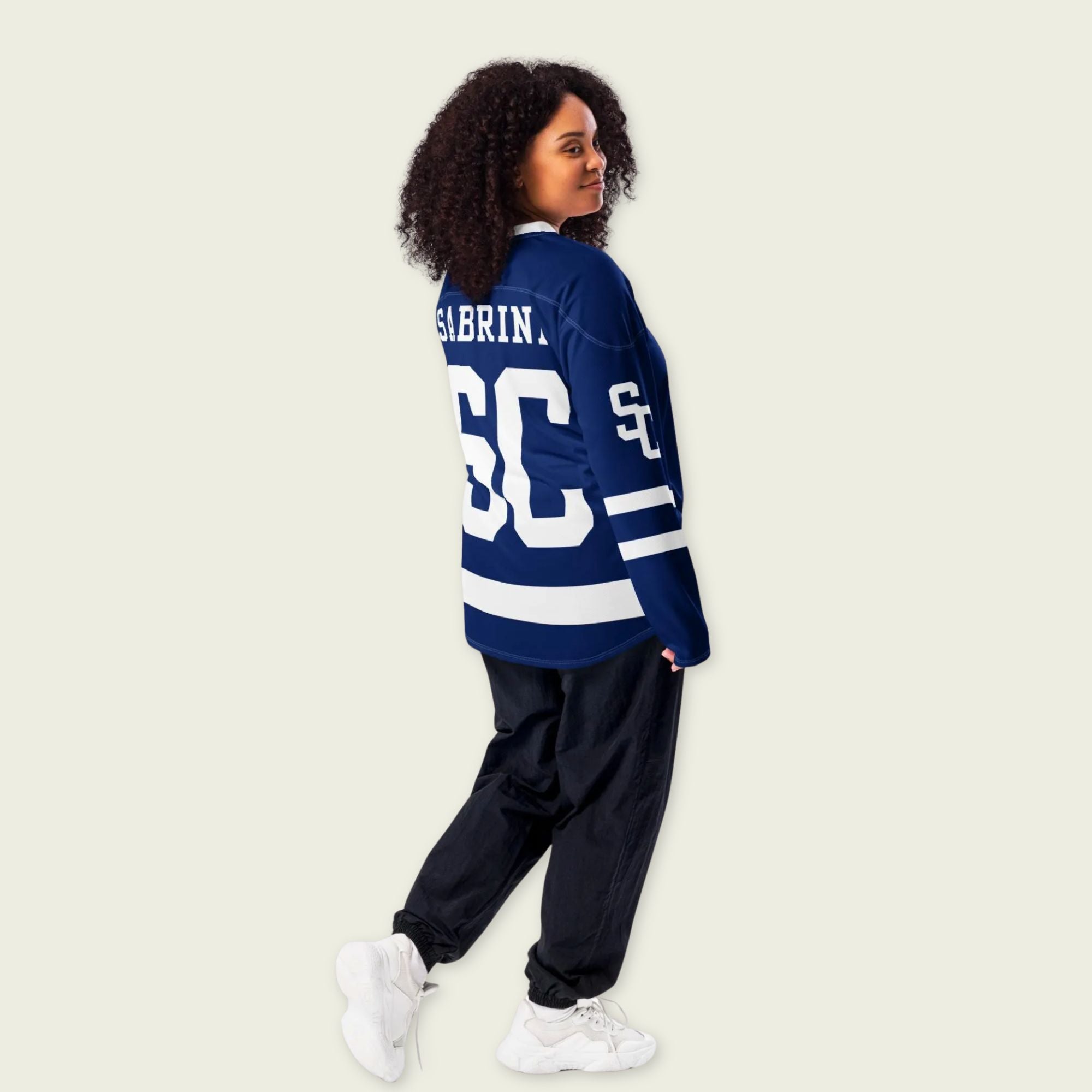 Person wearing a blue sports jersey with 'Sabrina' and number '68' on a beige background
