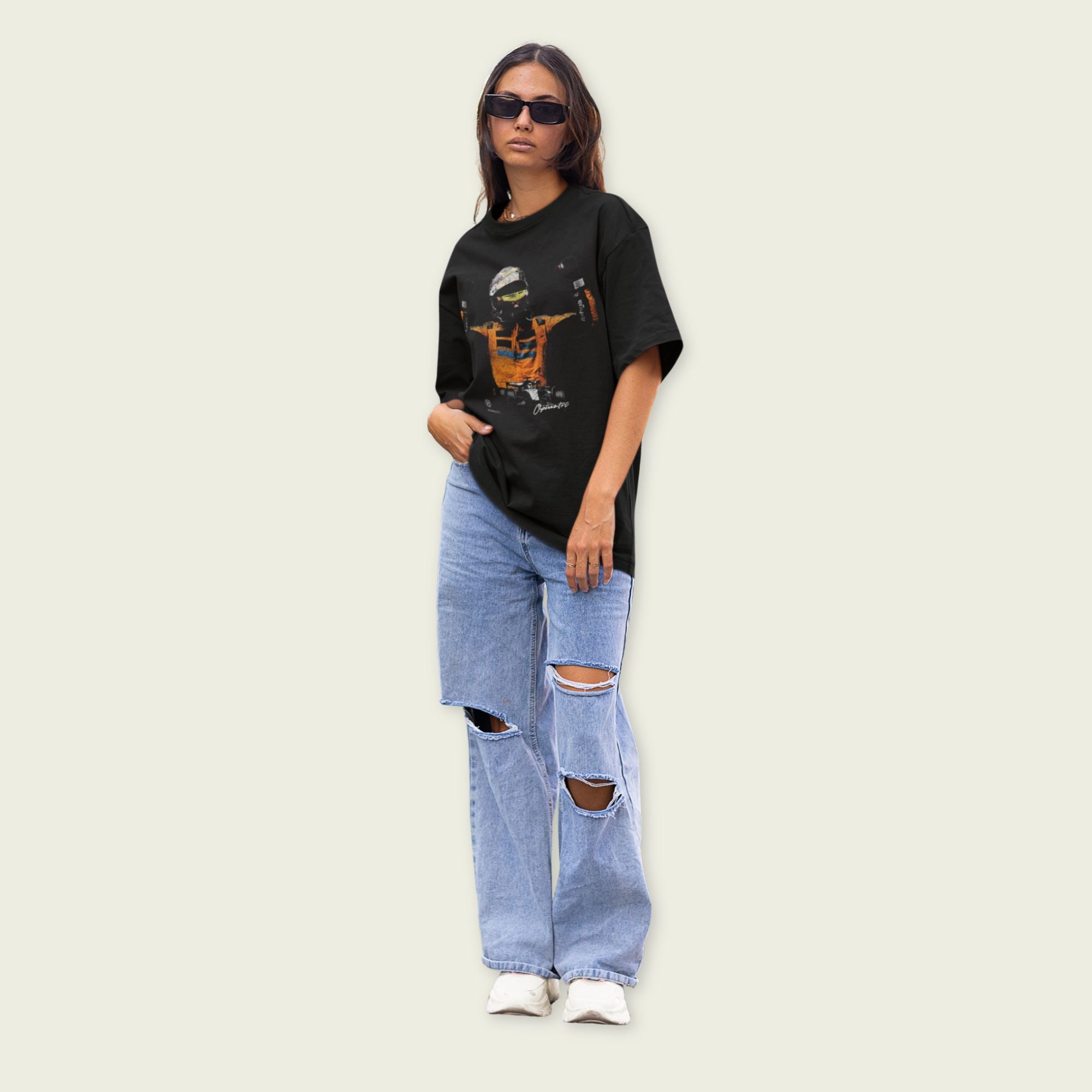 Person wearing a black graphic t-shirt and ripped jeans on a plain background