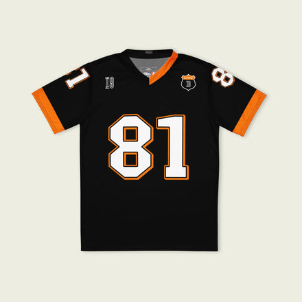 A black and papaya orange football jersey with Oscar Piastri's McLaren F1 racing number 81 on the back and front in white. It has the name Piastri in orange on the front as well.