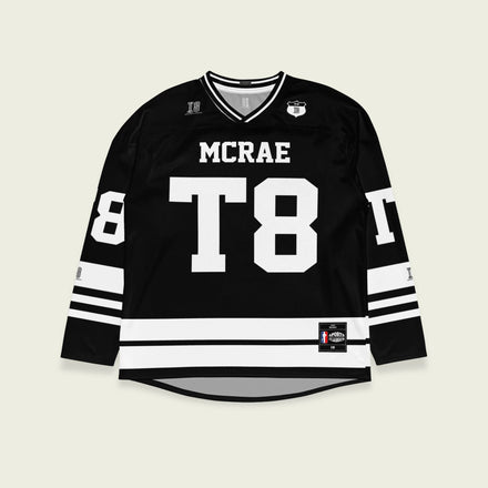 A black and white hockey jersey with the name Mcrae in white on the front and back. Also T8 in white on the front and back.